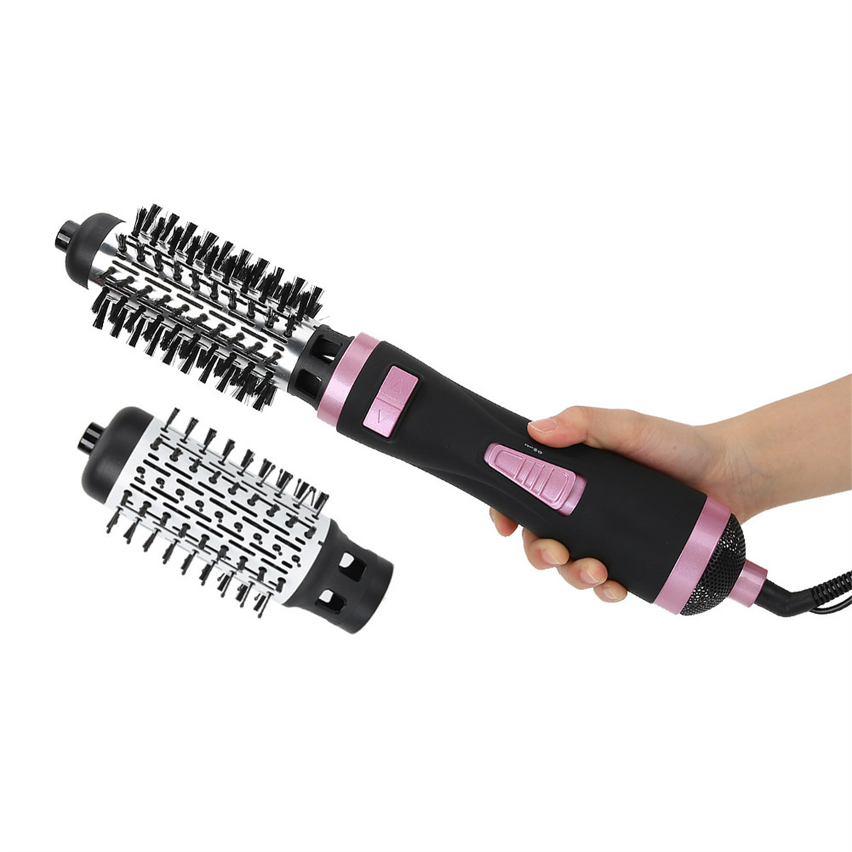 Ein schwarzer und rosa Haartrockner und zwei Bürstenaufsätze werden von einer Hand vor weißem Hintergrund gehalten.