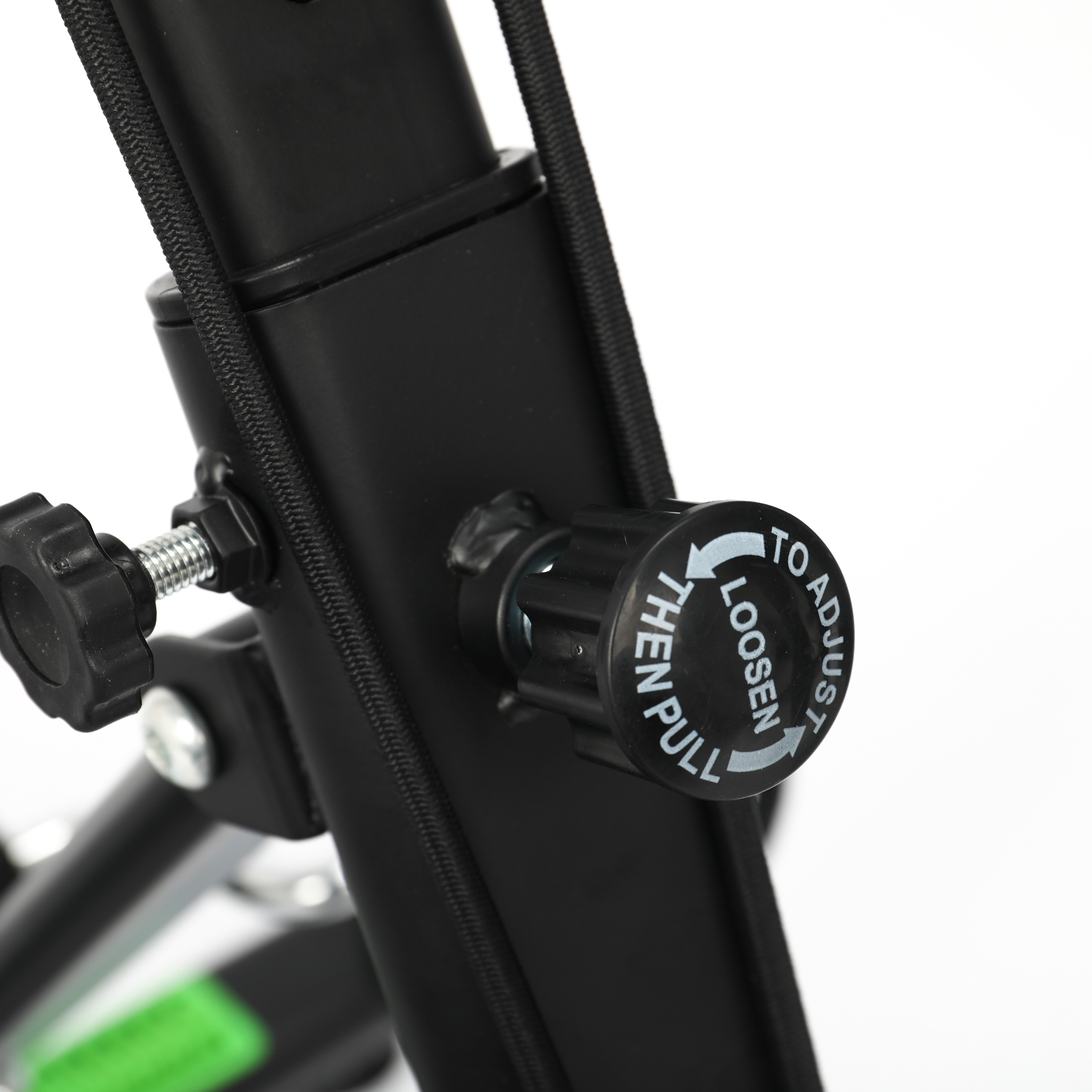 Primer plano de un dial negro con instrucciones, parte de una bicicleta estática negra.