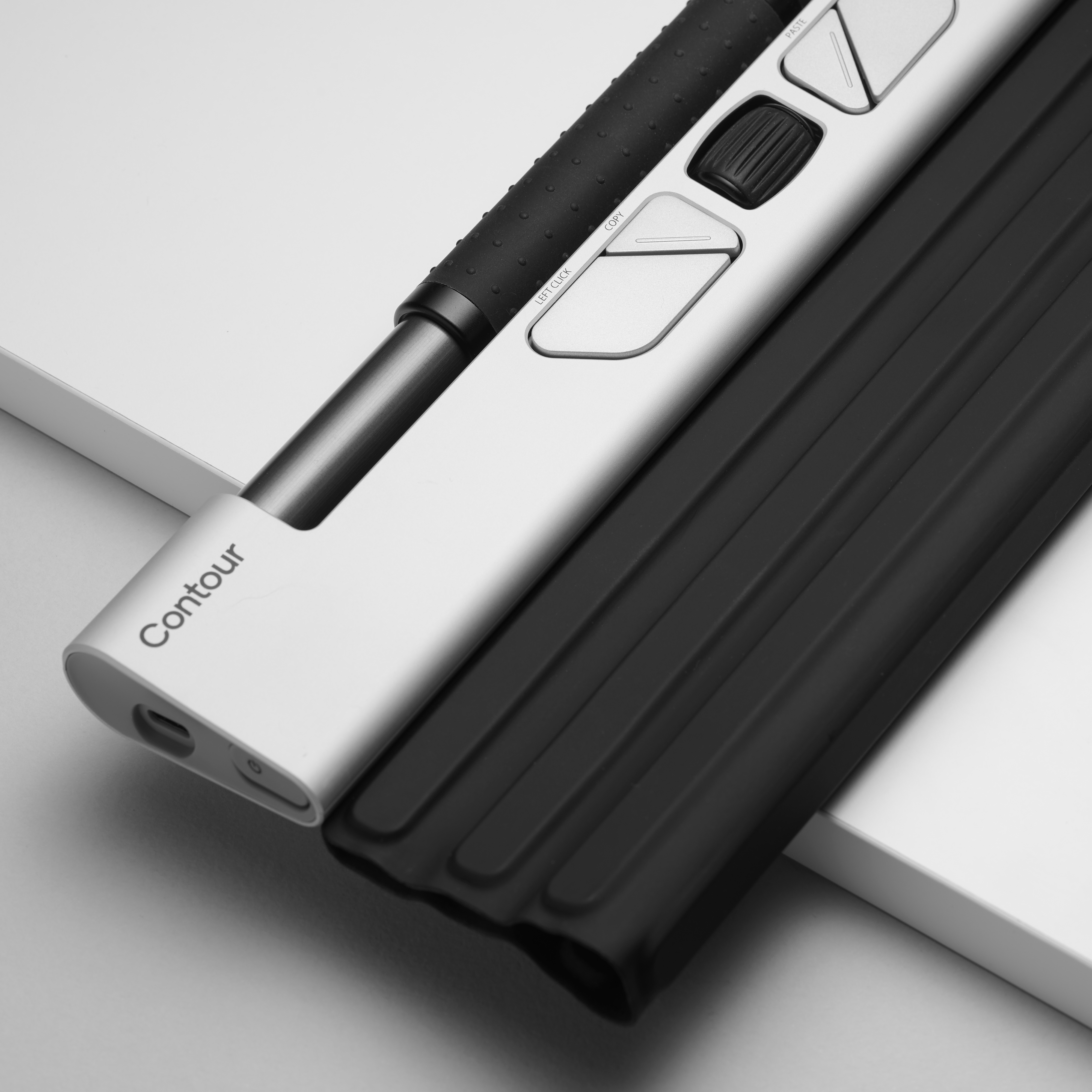 Close-up of a Contour mouse. It has buttons, a scroll wheel, and a black grip.