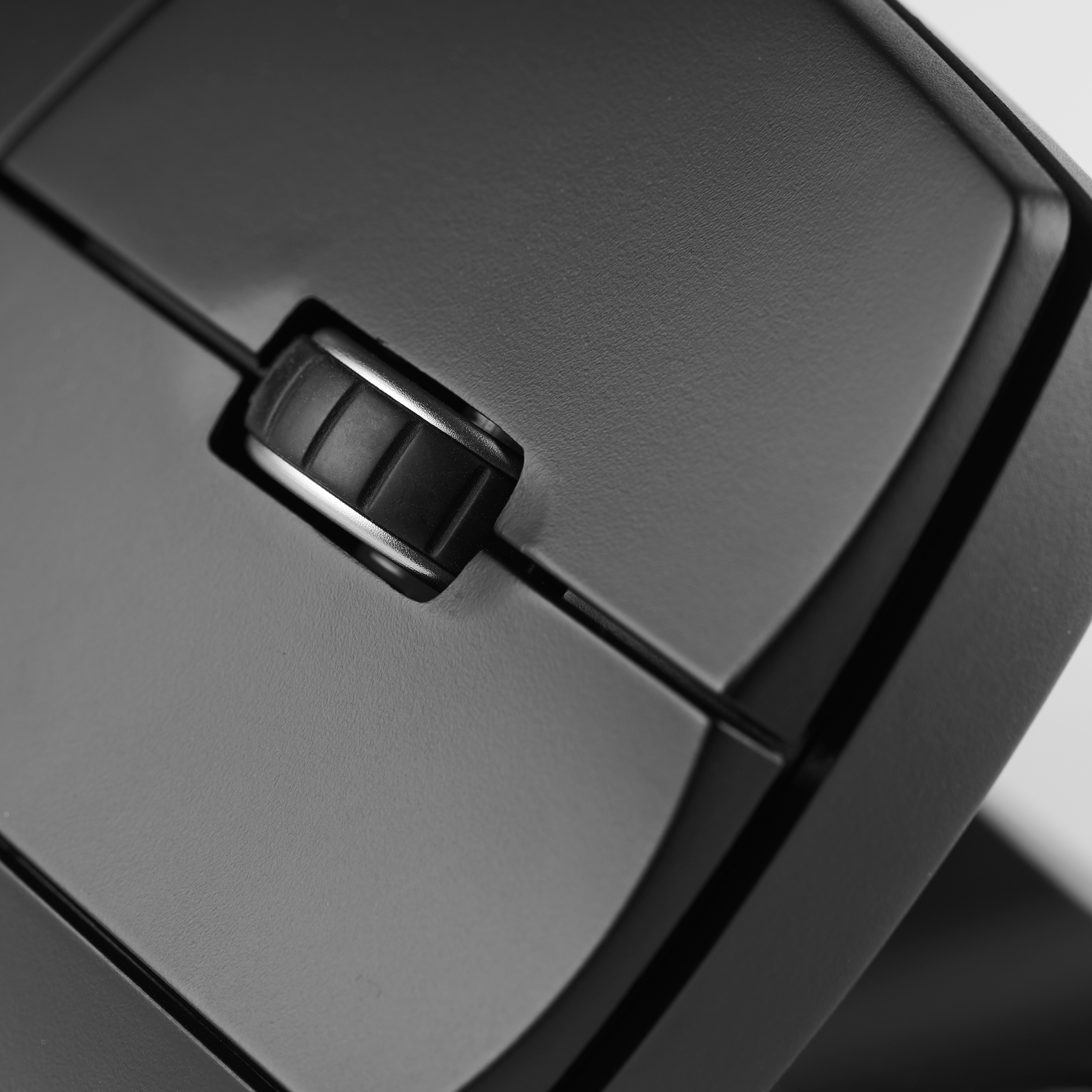 Close-up van een zwarte muis met een scrollwiel en knoppen, met een strak ontwerp.