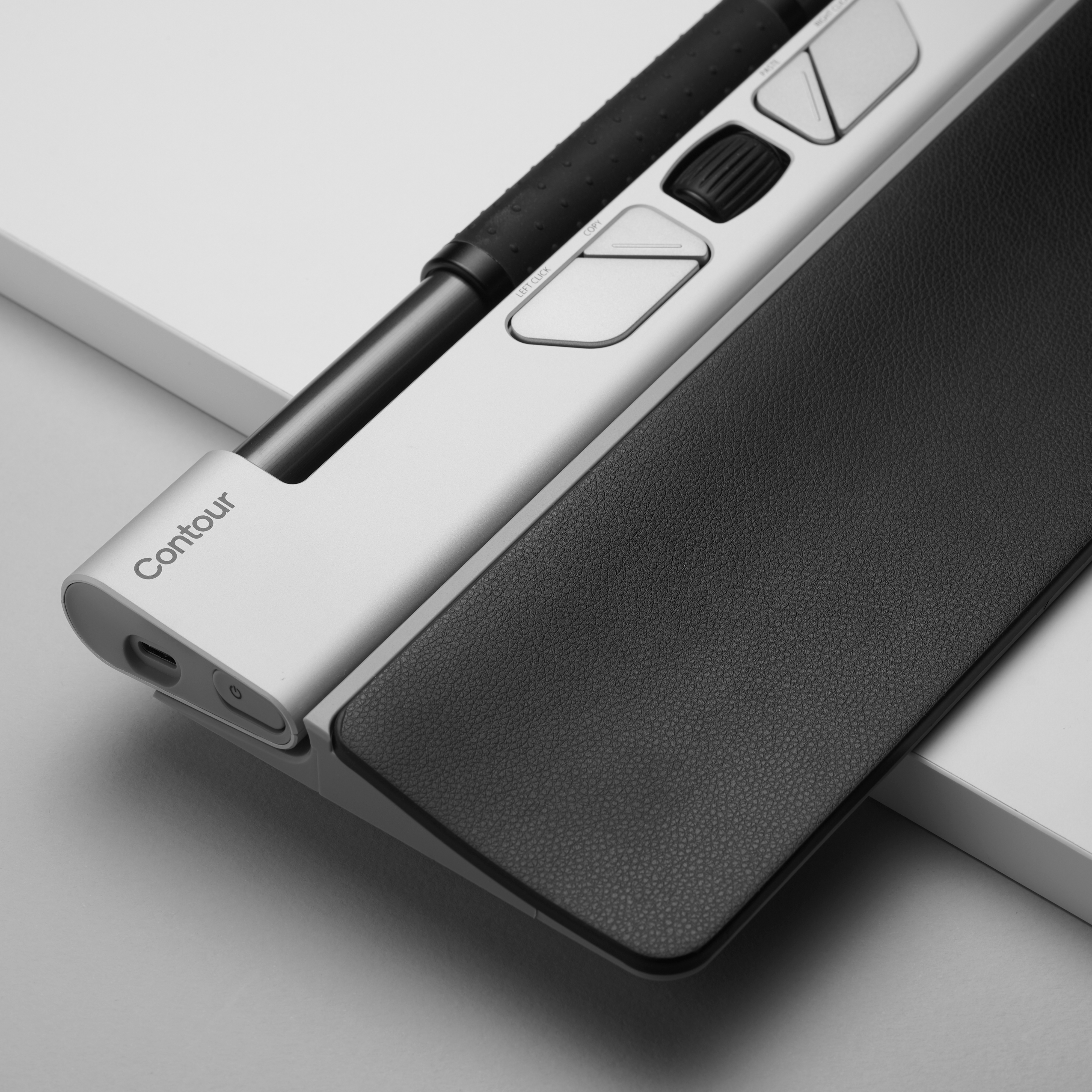 Ergonomiczna mysz Contour ze srebrną obudową i czarnym, teksturowanym uchwytem i przyciskami.