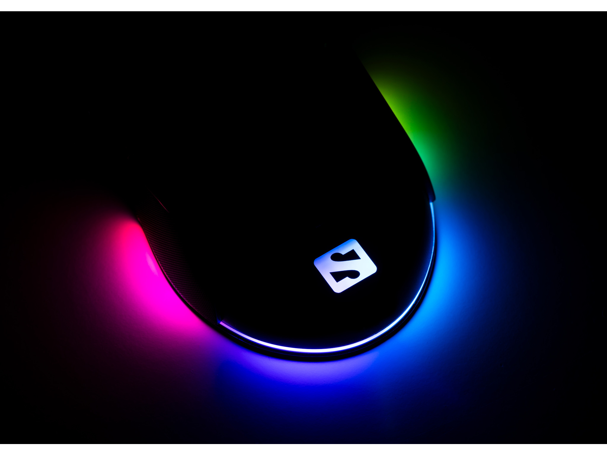 Zwarte gamingmuis met RGB-verlichting en logo tegen donkere achtergrond.