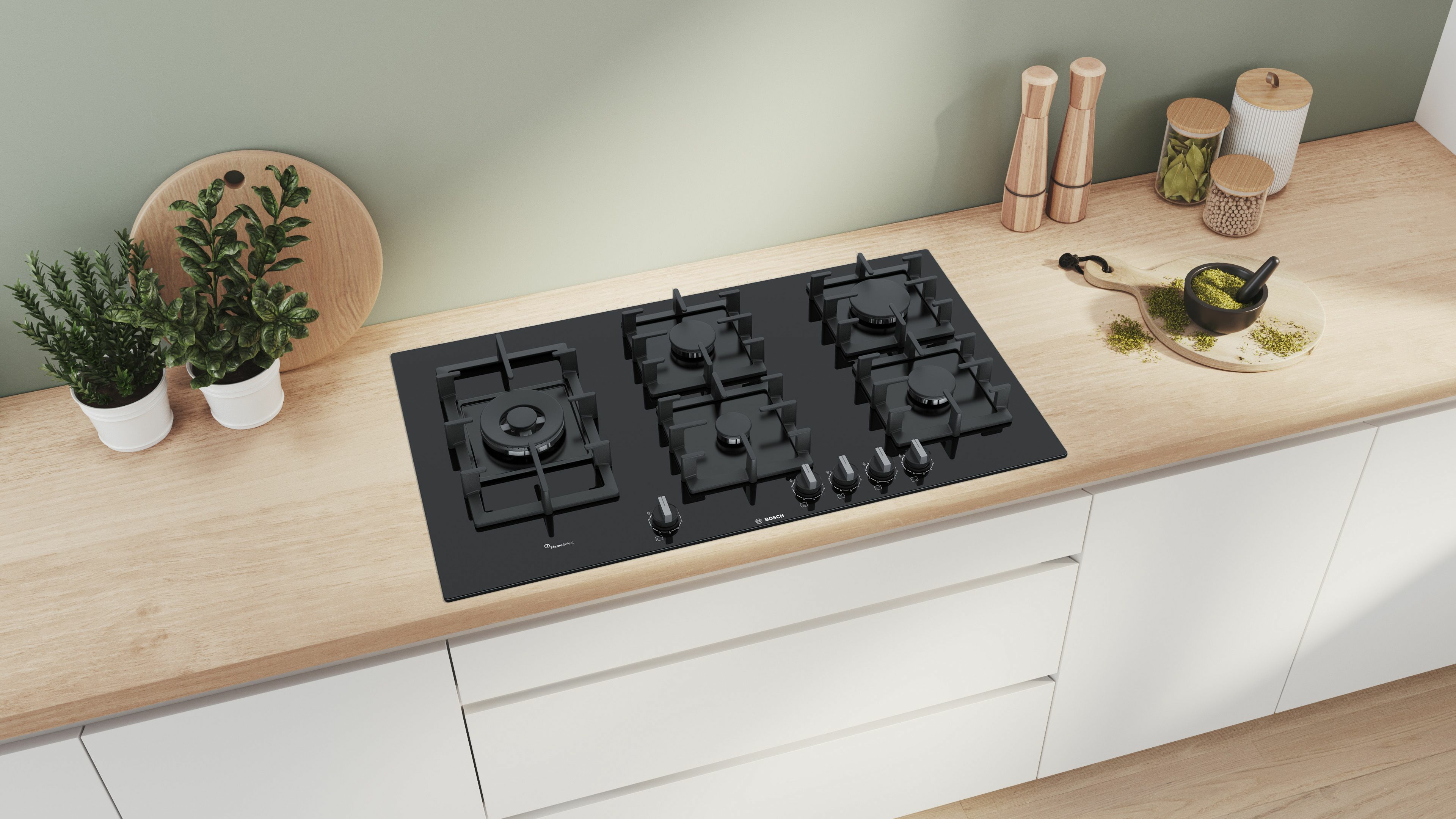 Black gas cooktop on a wooden countertop, with white cabinets.