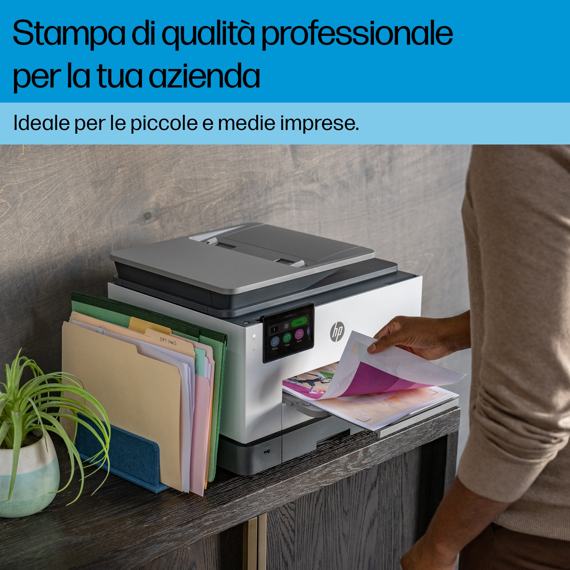 Persona sosteniendo papel frente a impresora, con texto arriba.