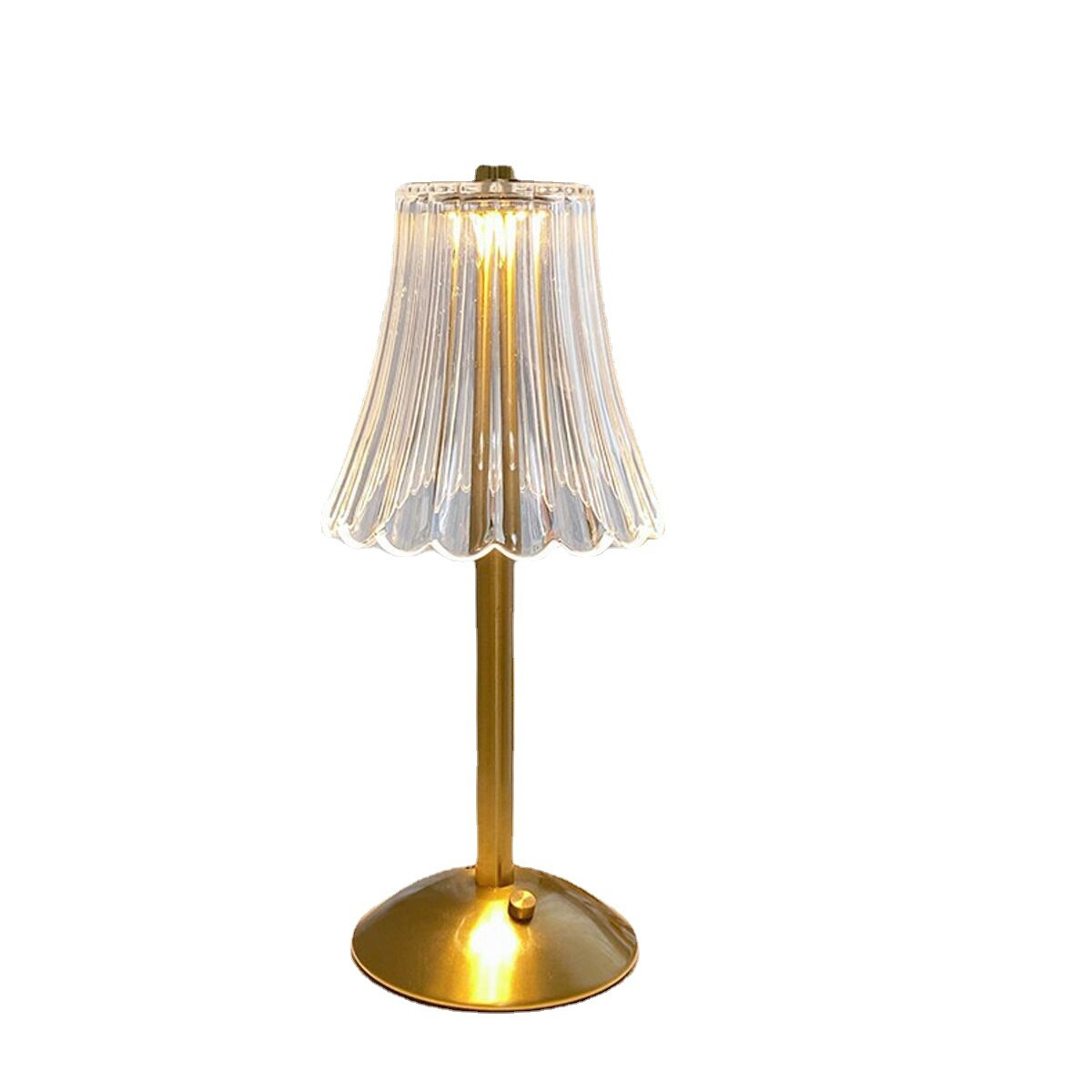 Eine kleine, goldfarbene Tischlampe mit Glasschirm. Weißer Hintergrund.