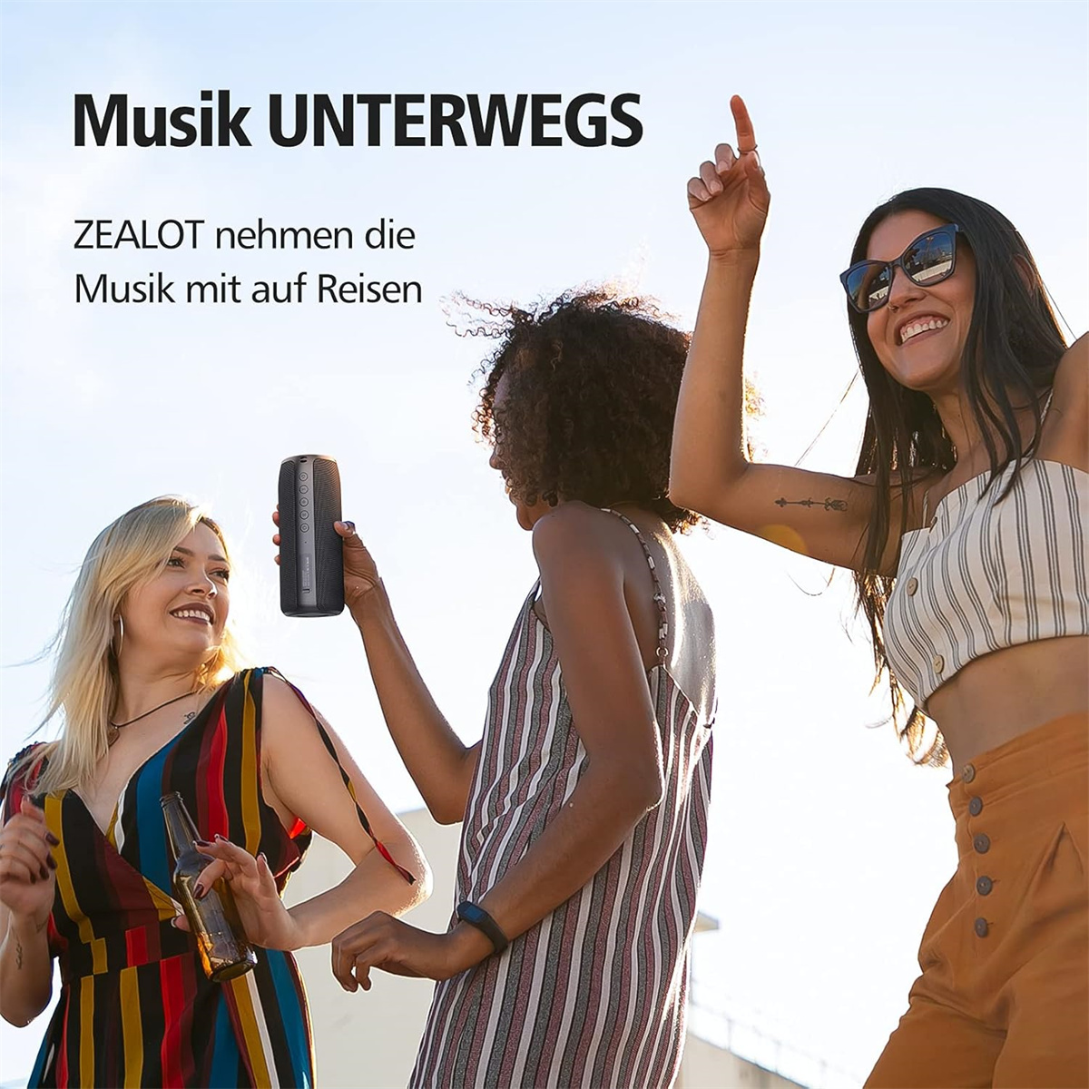 Drei lächelnde und tanzende Menschen mit einem schwarzen Lautsprecher. Der Text: Musik UNTERWEGS.