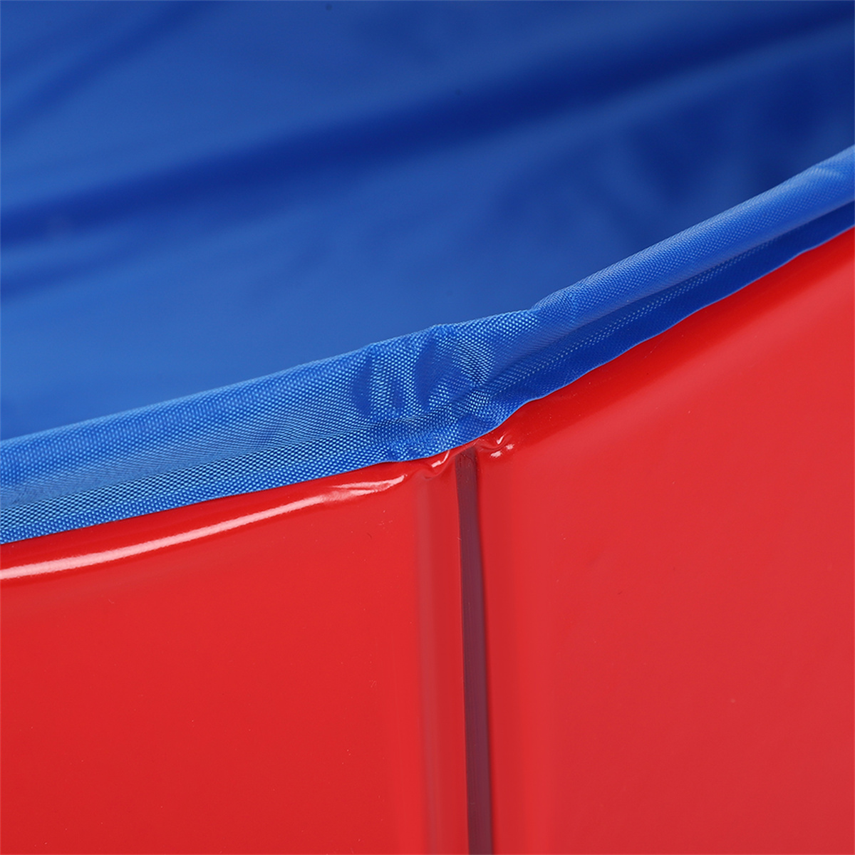 Nahaufnahme eines rot-blauen Plastikbehälters. Der blaue Rand ist oben und genäht.