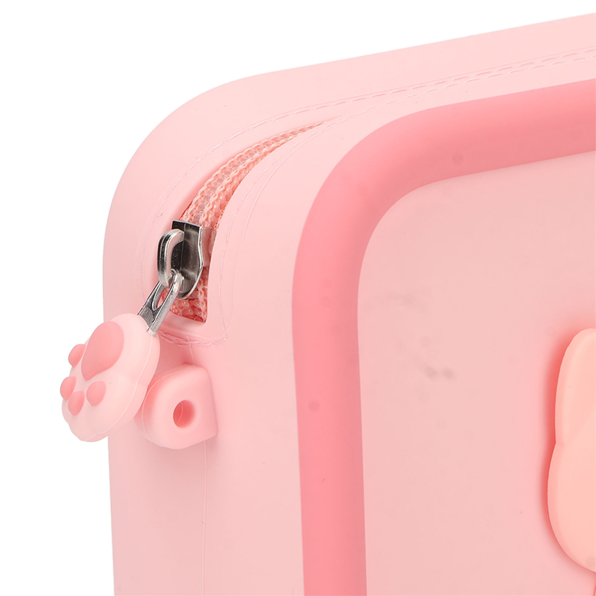 Nahaufnahme einer rosa, rechteckigen Box mit Reißverschluss und Pfoten-förmigem Zug.