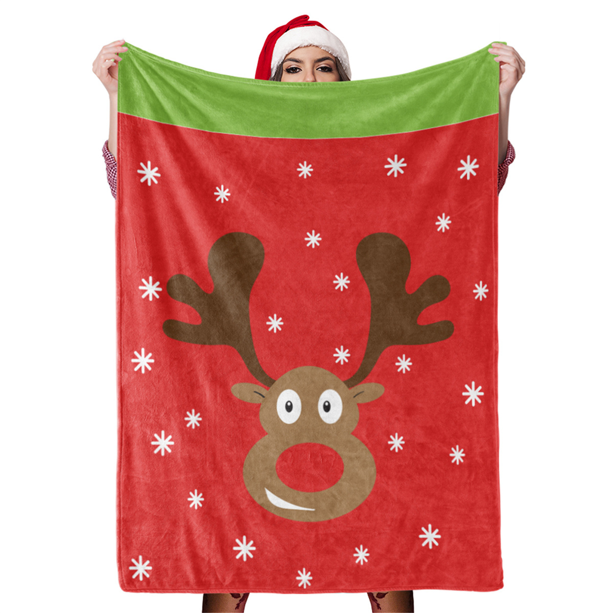 Person hält eine rote Weihnachtsdecke mit Rentier-Design und weißen Schneeflocken.