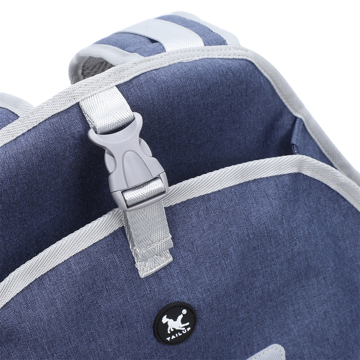 Nahaufnahme einer blauen Tasche mit grauer Schnalle und einem Tail Up Logo.