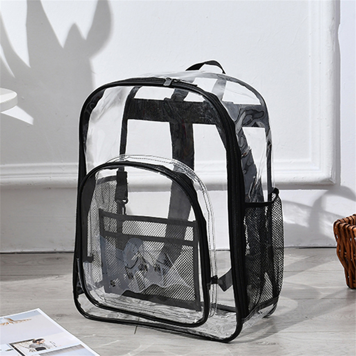 Ein durchsichtiger Rucksack mit schwarzen Akzenten. Der Rucksack hat ein Hauptfach und eine Vordertasche.