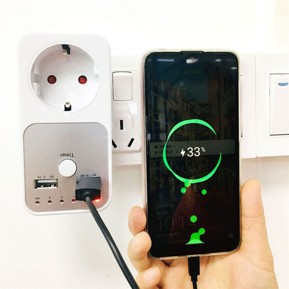 Ein Telefon wird geladen, zeigt 33%. Es ist an eine Steckdose mit Timer und USB-Anschlüssen angeschlossen.