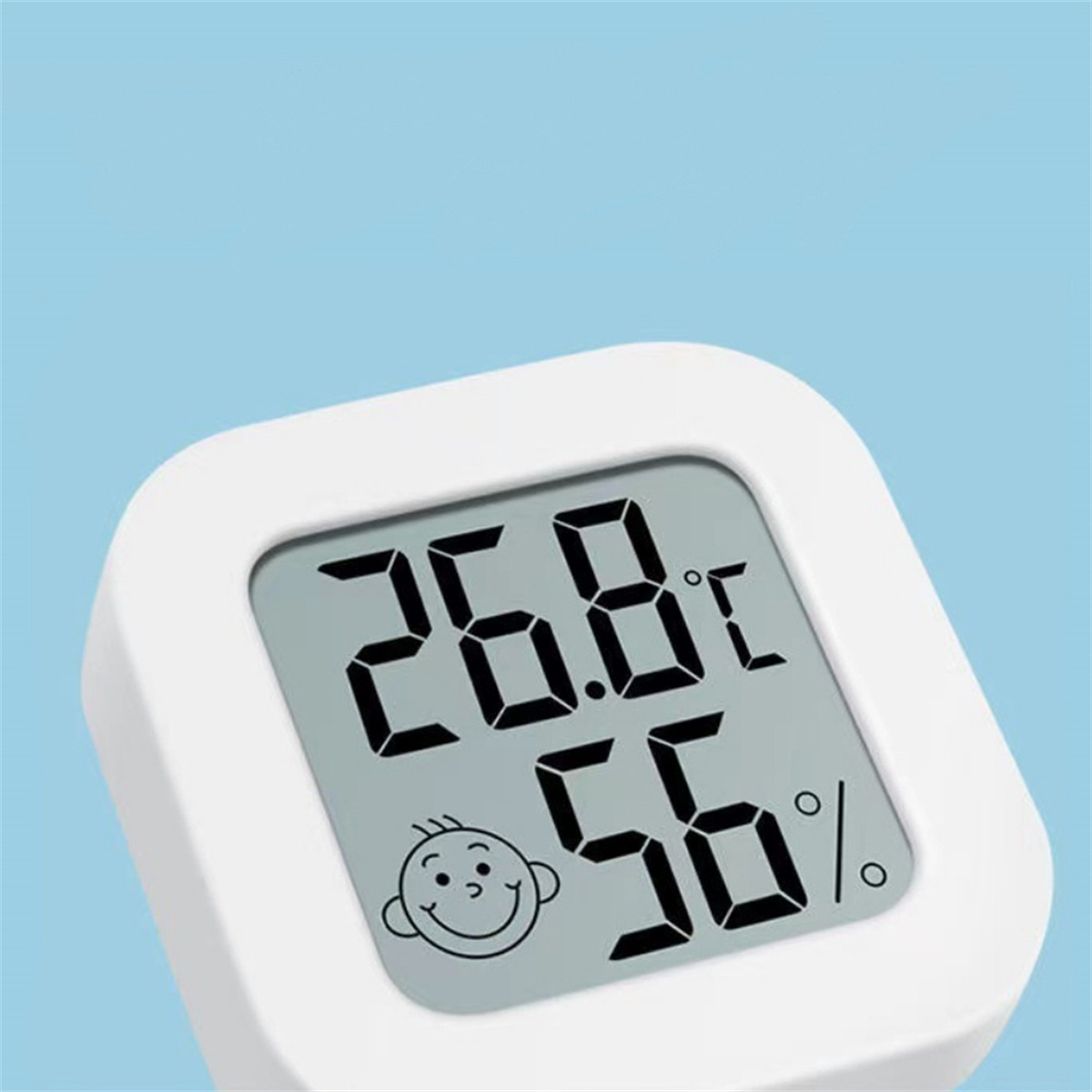 Weißes digitales Thermometer mit 26,8 °C und 56 %. Es hat auch ein lächelndes Gesichtssymbol.