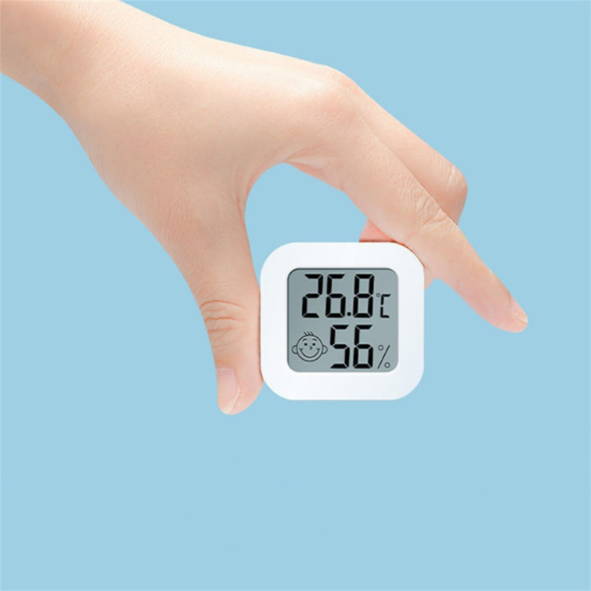 Person hält ein kleines, weißes Digitalthermometer mit 26,8 °C und 56 %.
