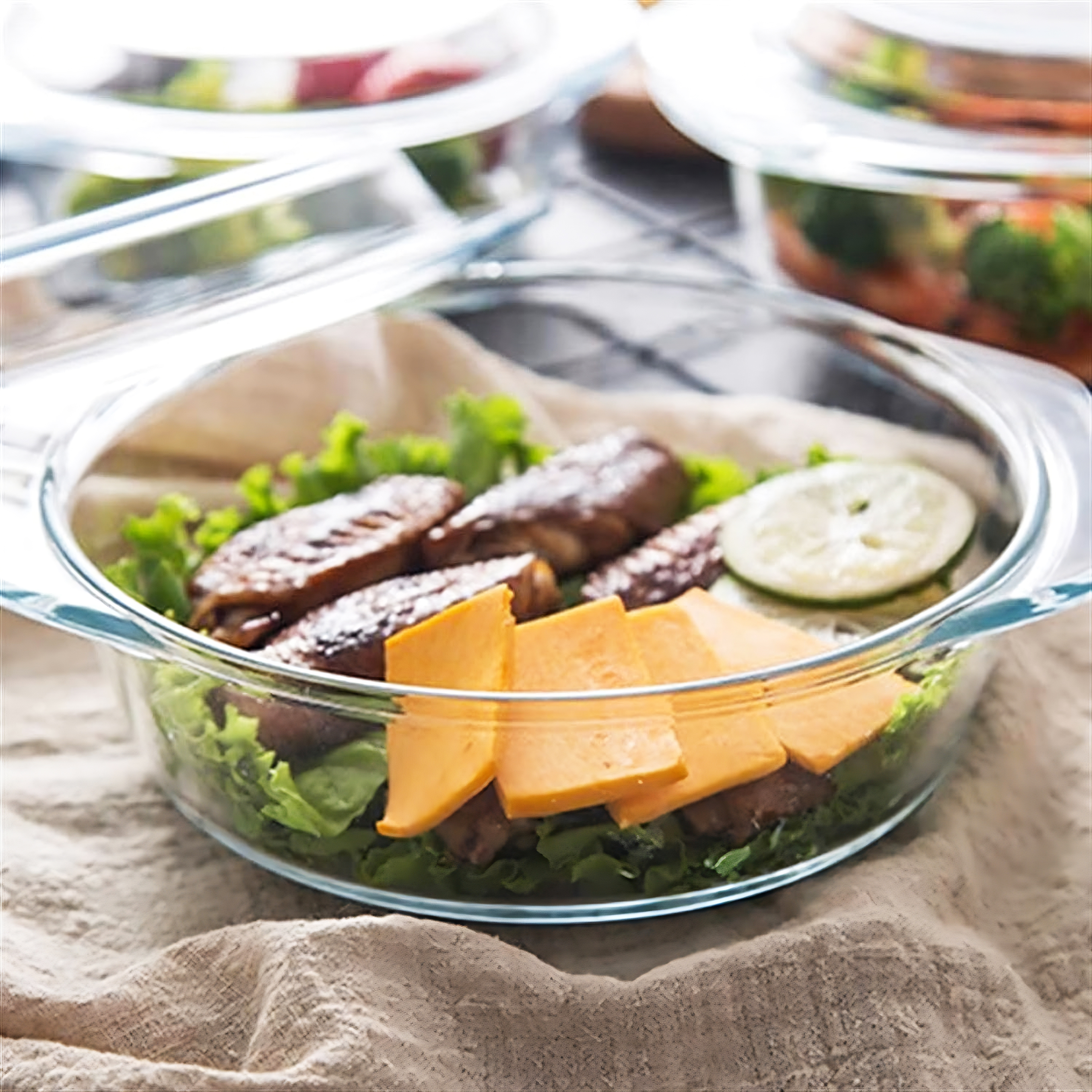 Eine Glasschale mit gekochtem Essen: Hähnchen, Salat, Käse und Limette.