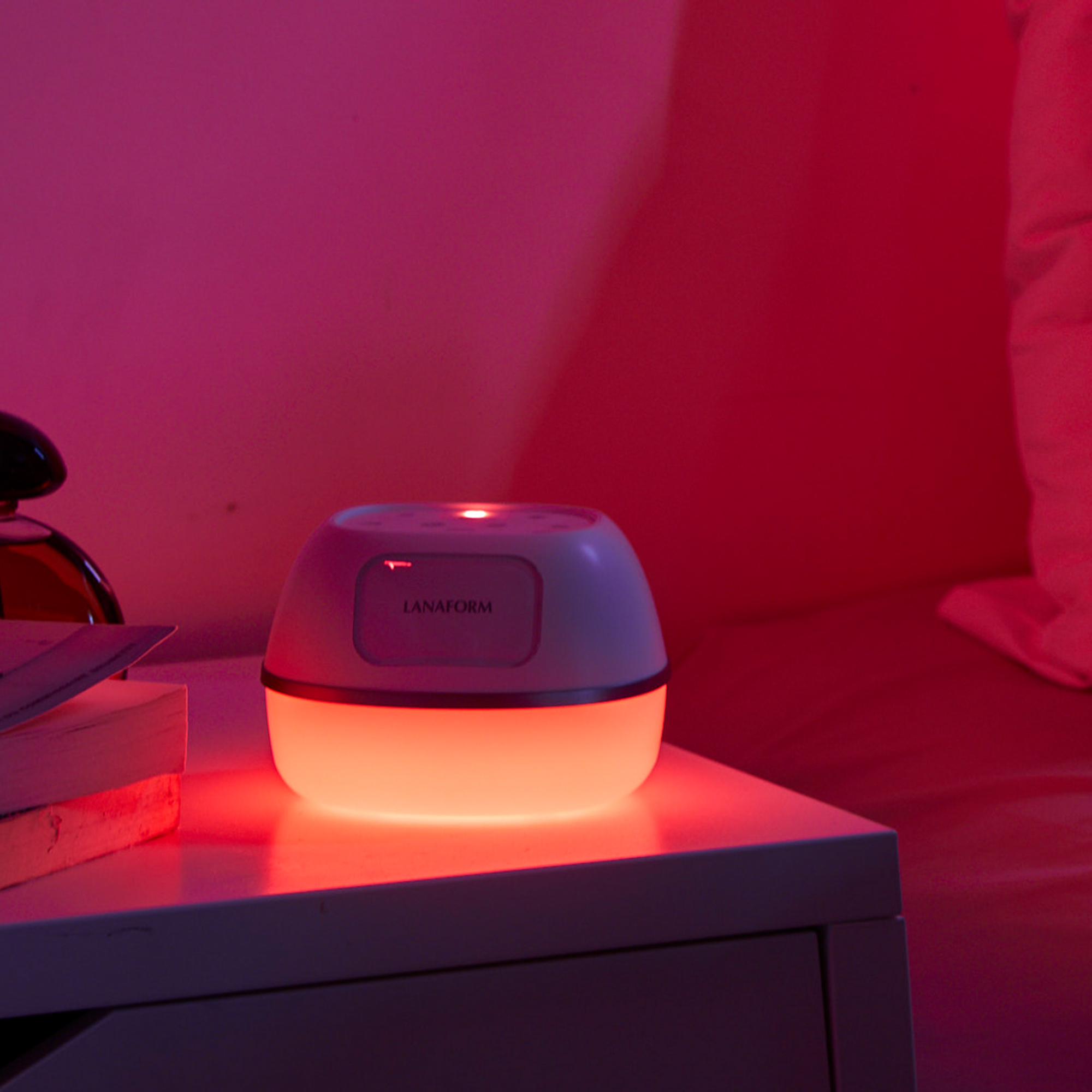 White and red night light on a bedside table, emitting a warm glow.