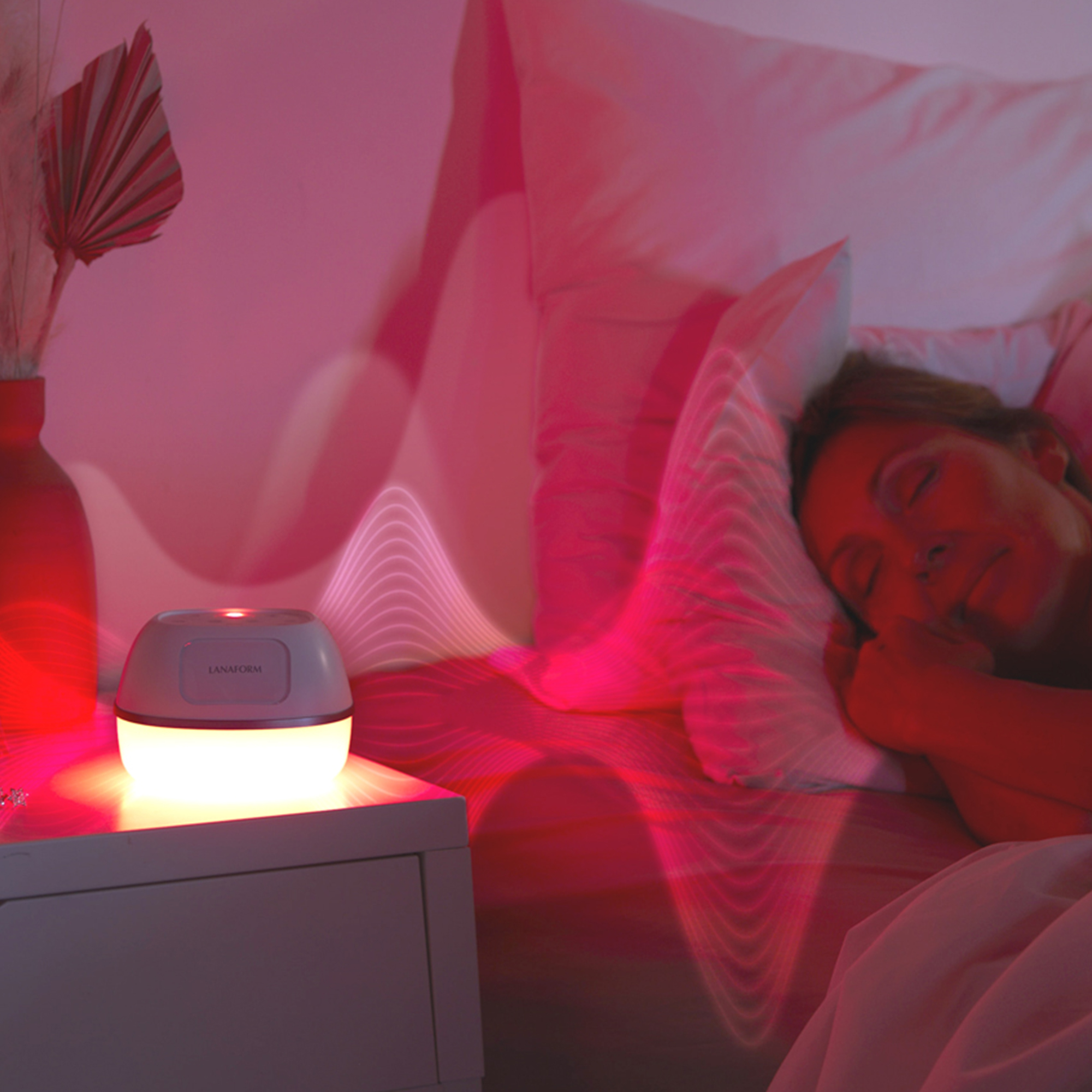 Woman sleeping in bed with a night light on a table. Pink ambiance.
