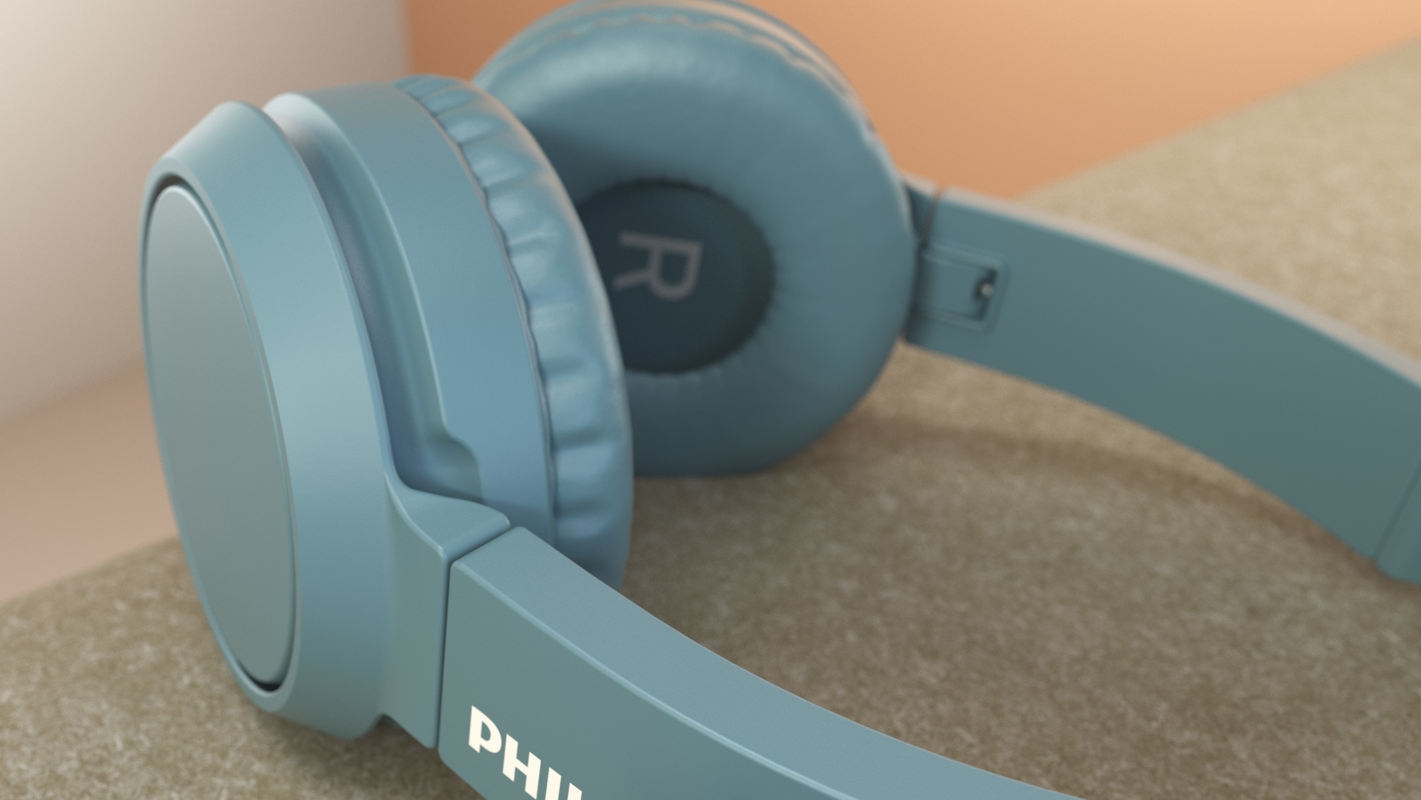 Auriculares azules con la letra 'R' en un auricular, sobre fondo marrón.