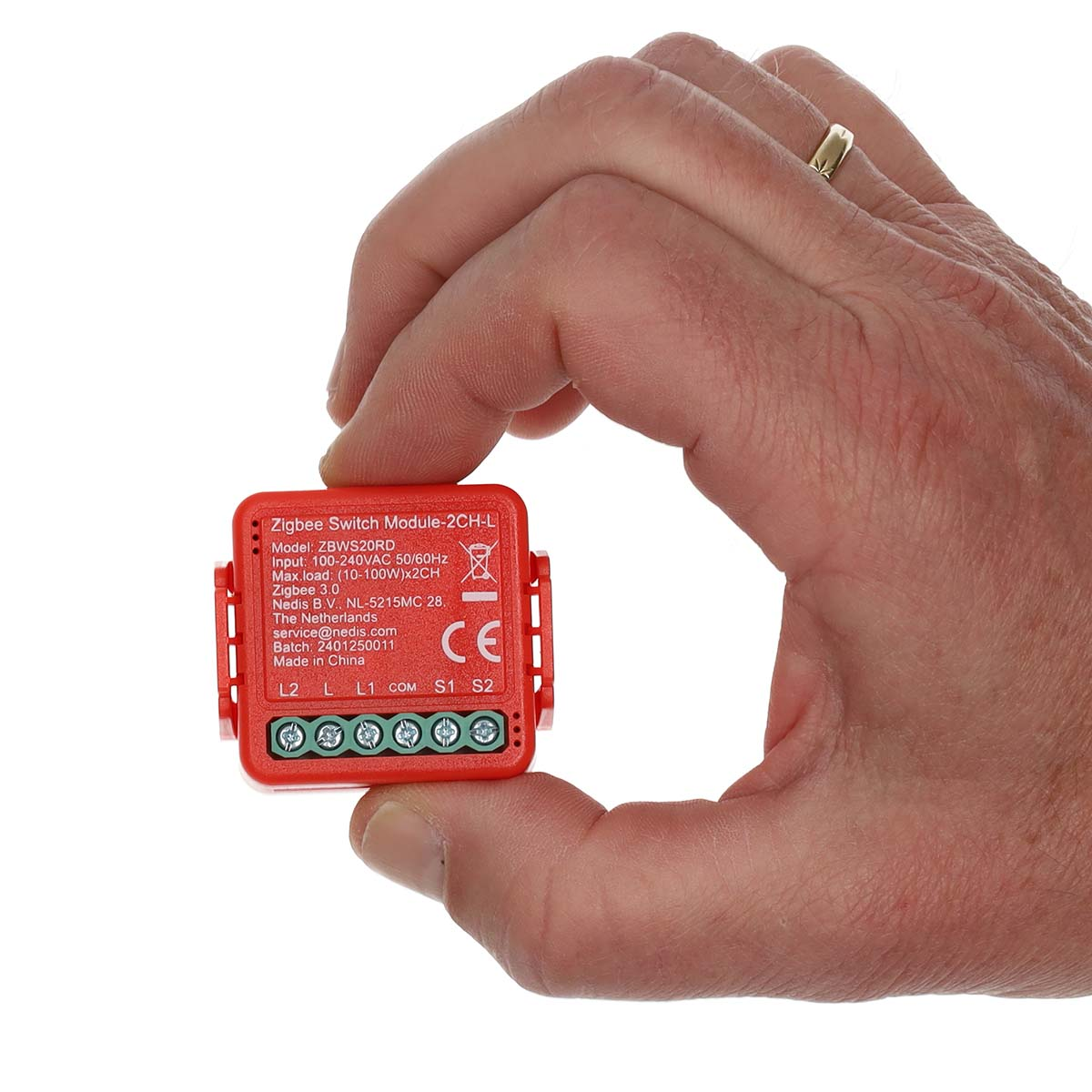 Eine Hand hält ein rotes Zigbee-Schaltermodul. Text und Symbole befinden sich auf dem Schalter.