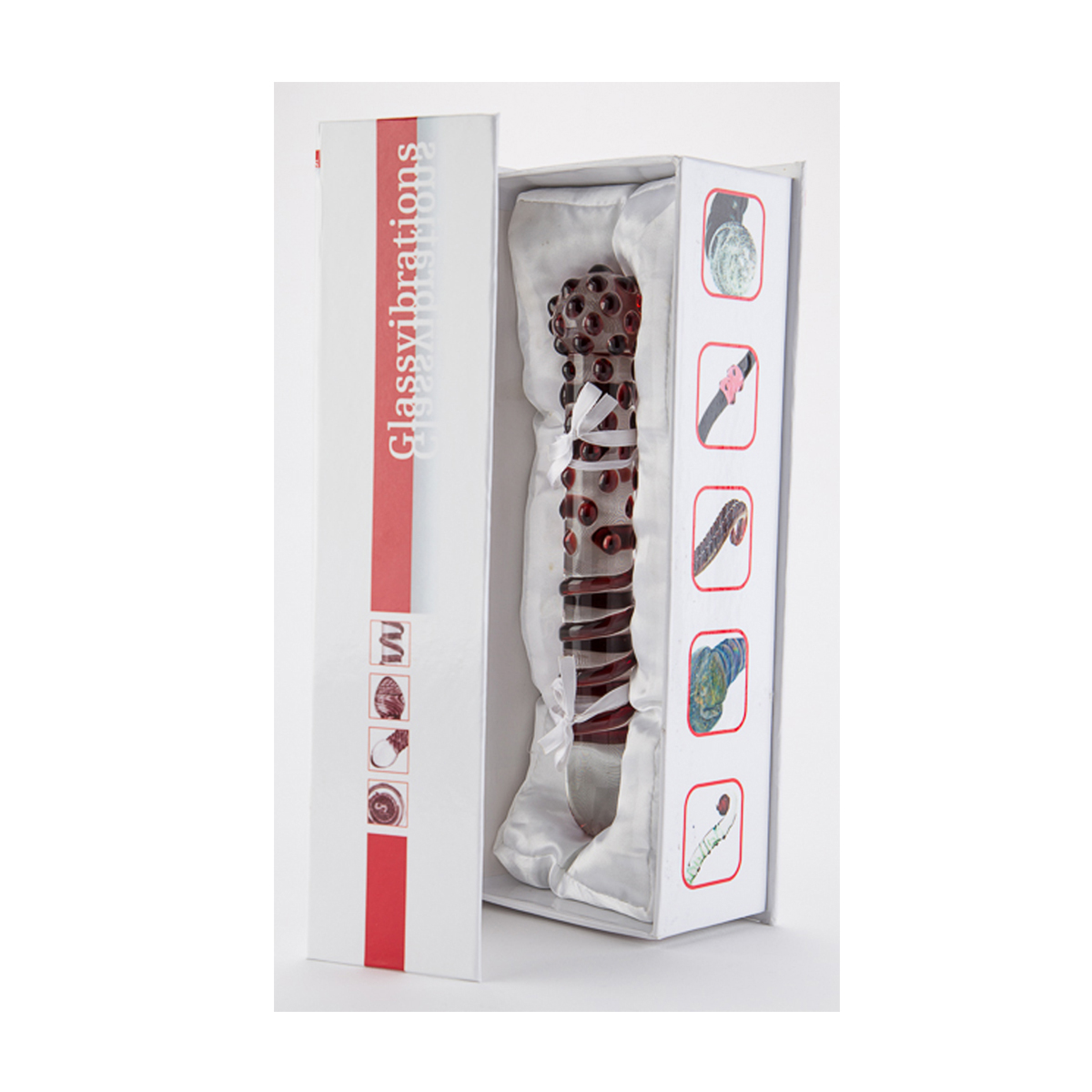 Ein roter Glasvibrator in einer weißen Box mit Illustrationen. Die Box hat einen roten Streifen.