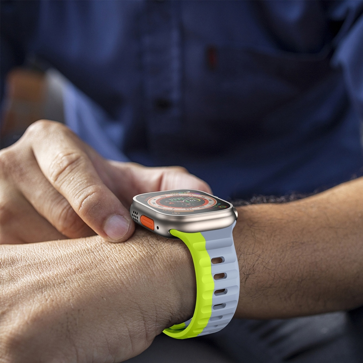 Una persona che indossa uno smartwatch con cinturino grigio e giallo al polso.