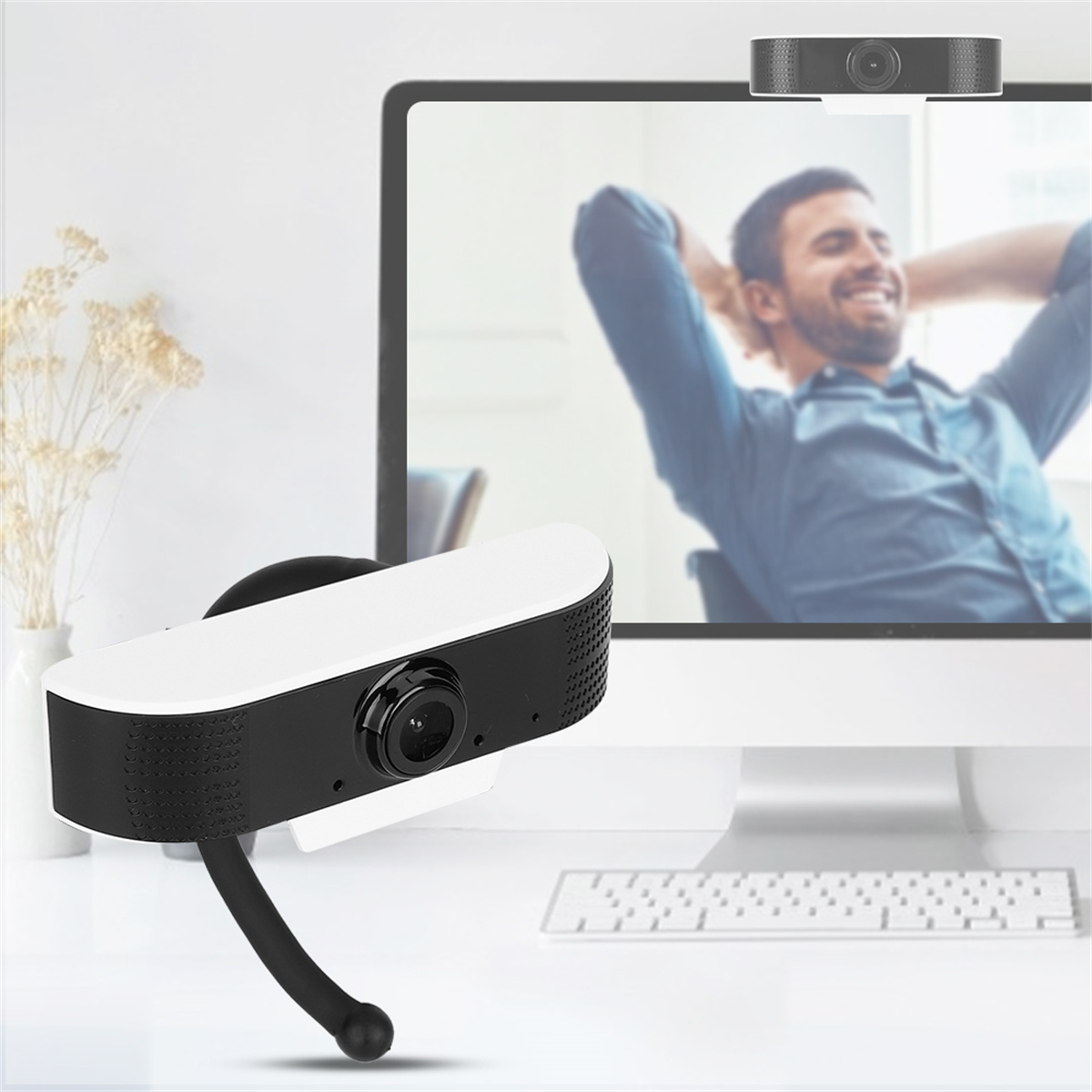 Webcam und Bildschirm mit einem lächelnden Mann im Hintergrund.