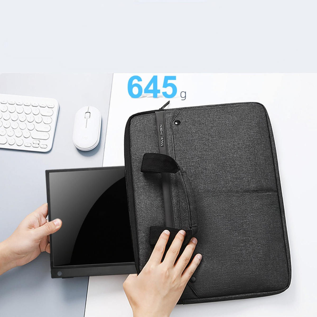 Laptoptasche mit Laptop, Maus und Tastatur. Die Tasche wird von Händen gehalten.