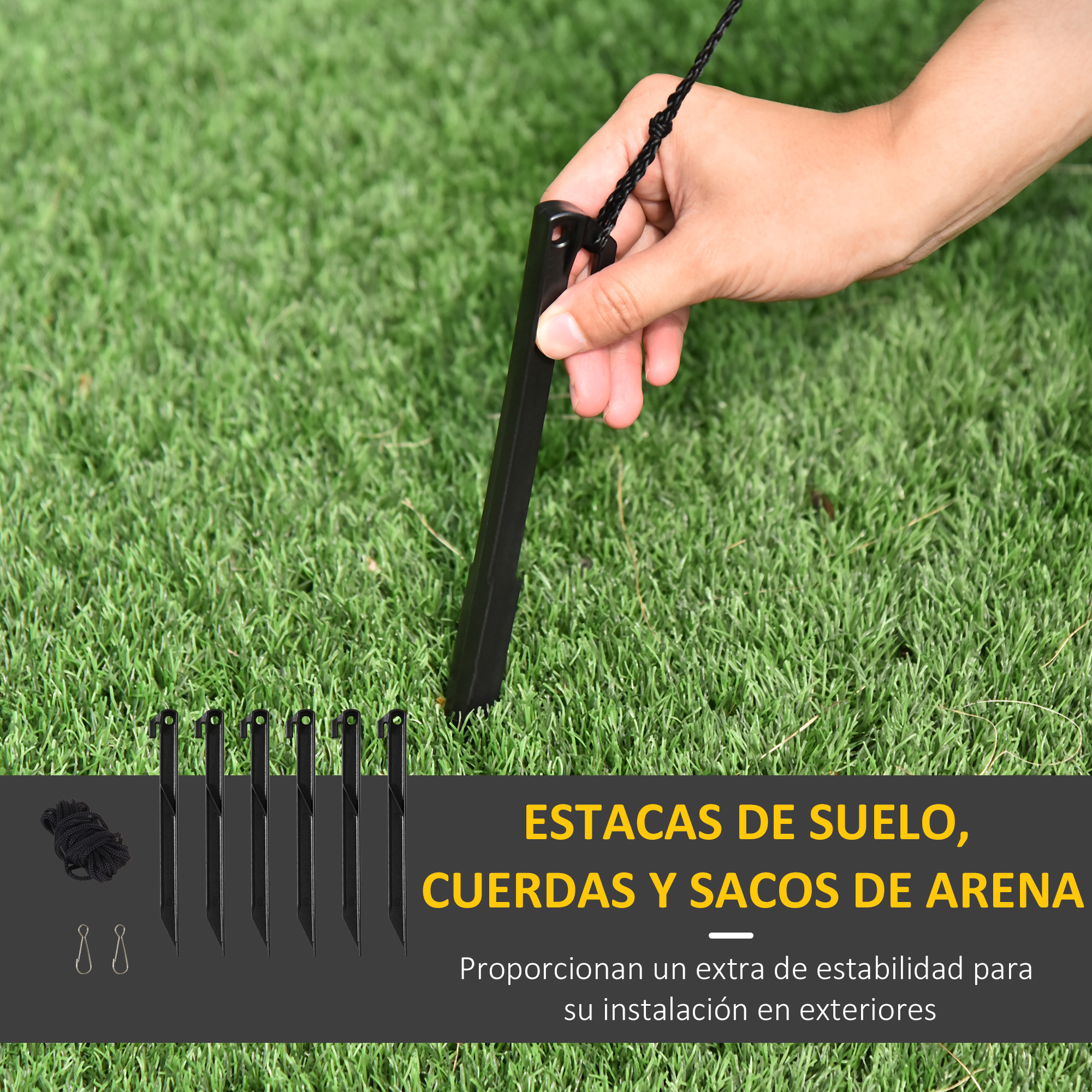 Estacas negras, cuerdas y sacos de arena sobre hierba verde, para instalación exterior.
