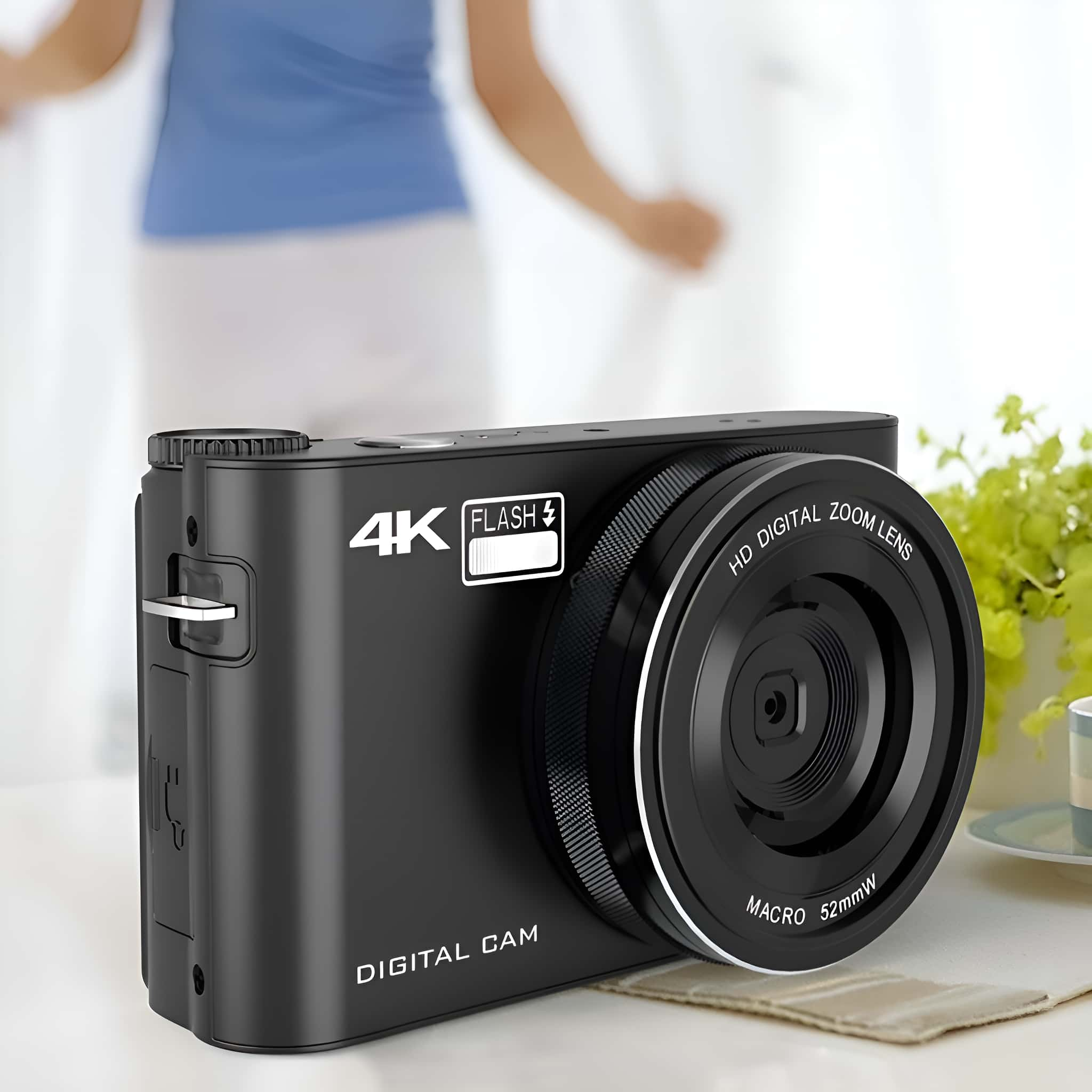 Eine schwarze Digitalkamera mit Zoomobjektiv und Blitz auf weißer Oberfläche.