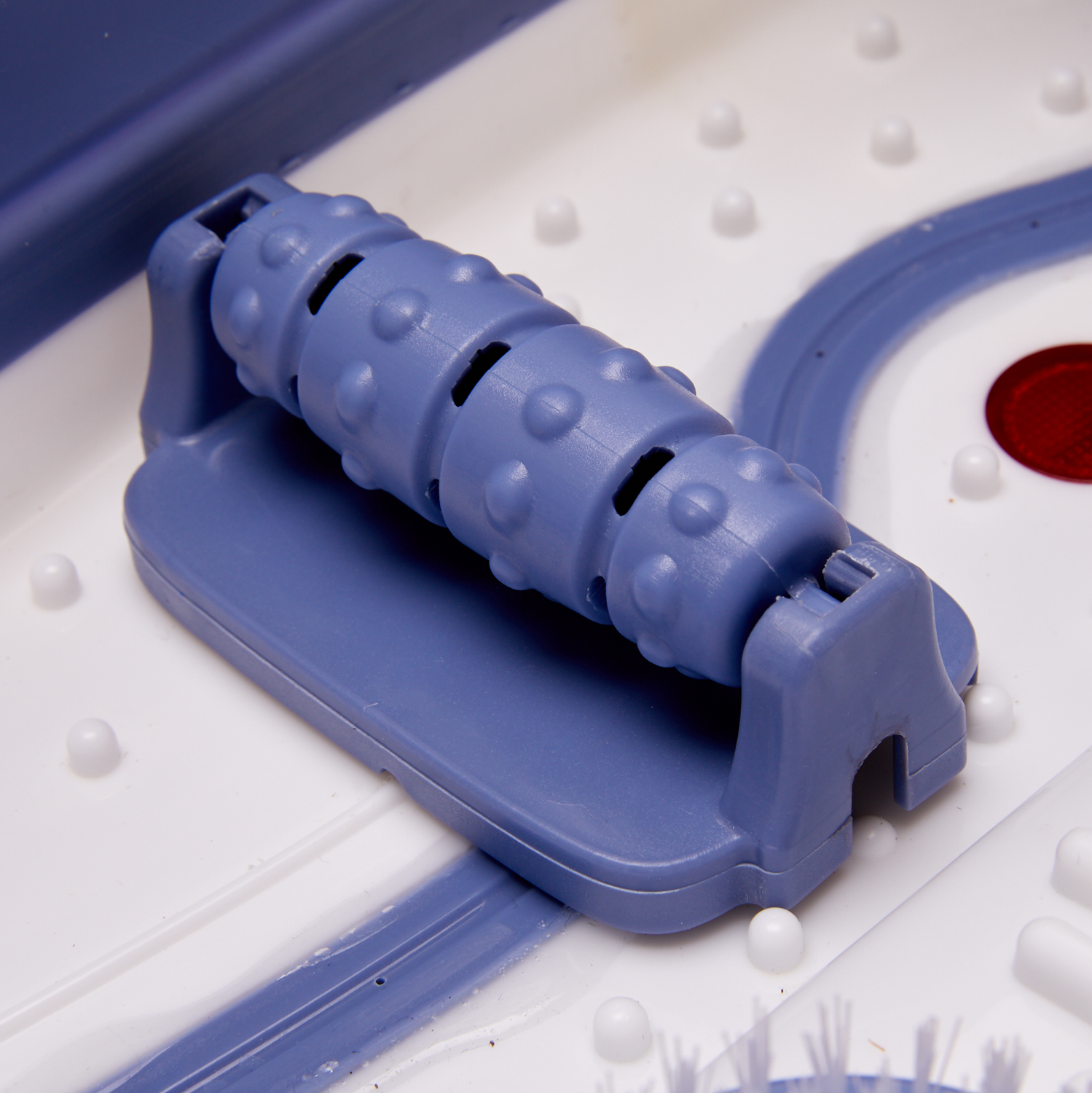 Blue foot massager in a white basin. Roller massager visible, with white and blue beads.