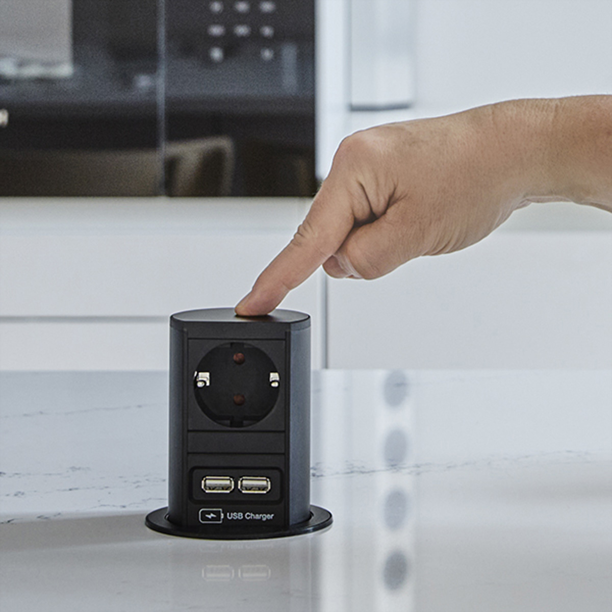 Een zwarte pop-up stopcontact met een vinger die erop drukt. Inclusief stopcontacten en USB-poorten.