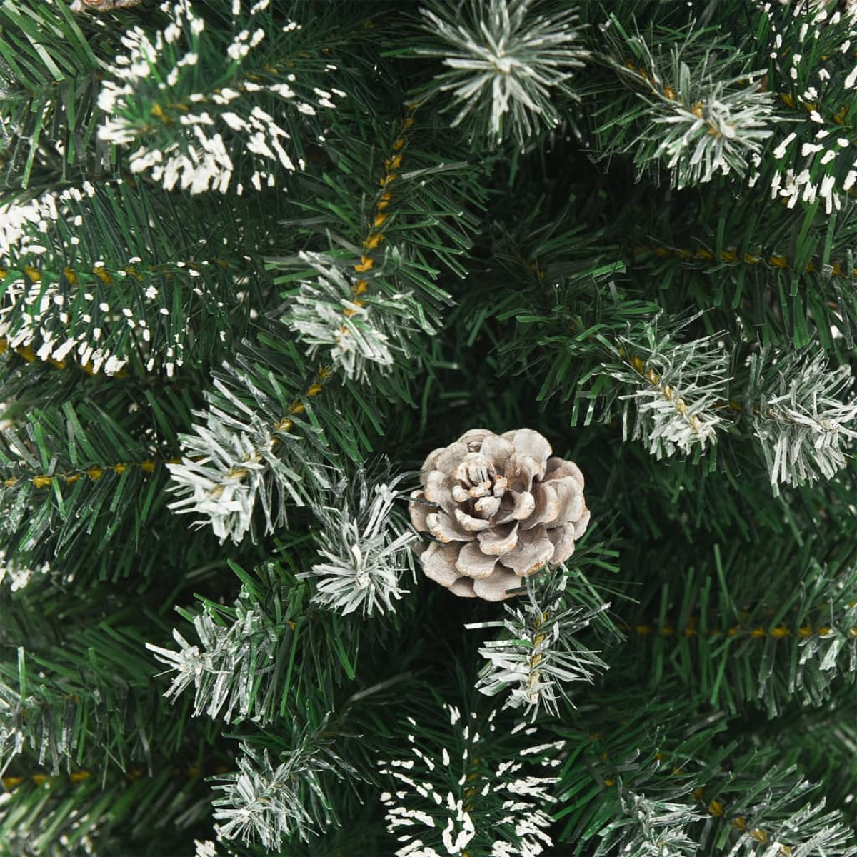 Nahaufnahme einer Tannenzapfen auf einem verschneiten Weihnachtsbaum. Die Nadeln sind grün.