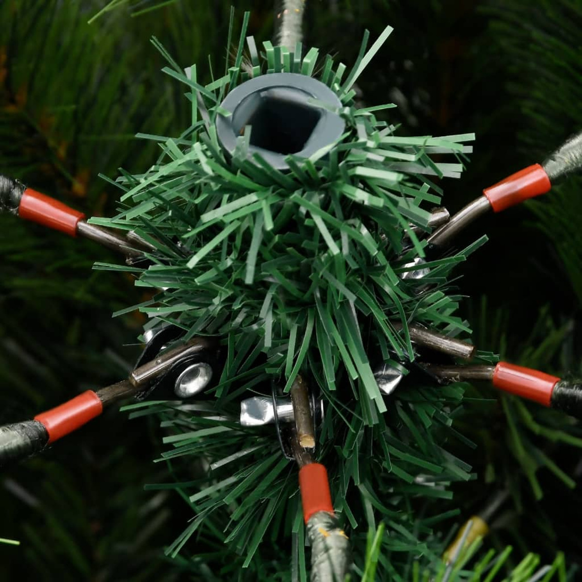 Nahaufnahme der Oberseite eines künstlichen Weihnachtsbaums, zeigt Verkabelung und rote Verbinder.