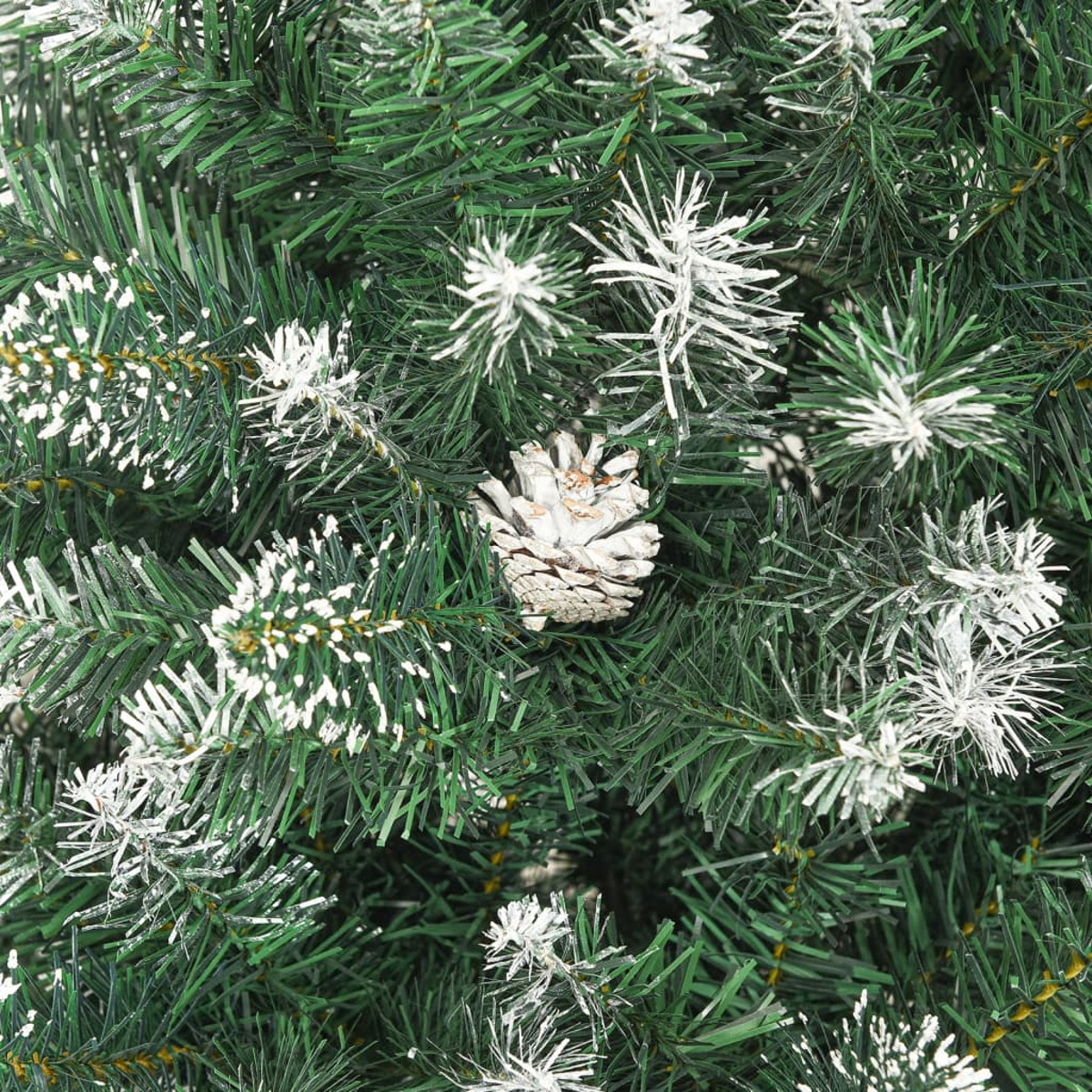 Nahaufnahme eines grünen Weihnachtsbaums mit Schnee und einem Tannenzapfen.