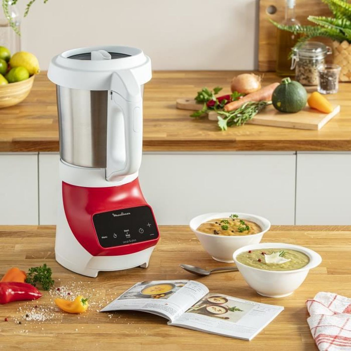 Robot da cucina bianco e rosso con ciotole e ingredienti su un tavolo di legno. Scena della cucina.