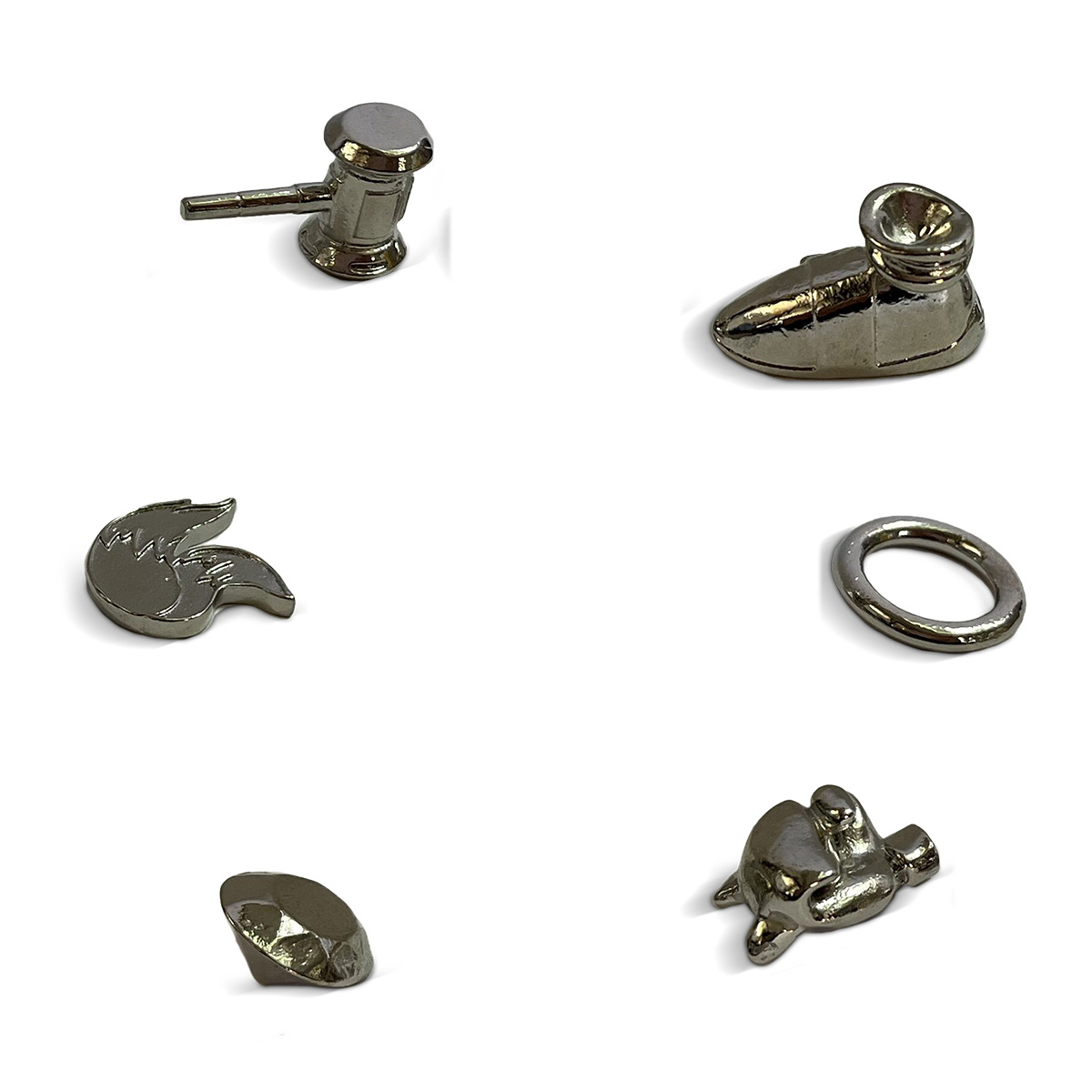 Sechs metallische Monopoly-Spielsteine: Hammer, Schuh, Flügel, Ring, Diamant und Schildkröte auf Weiß.