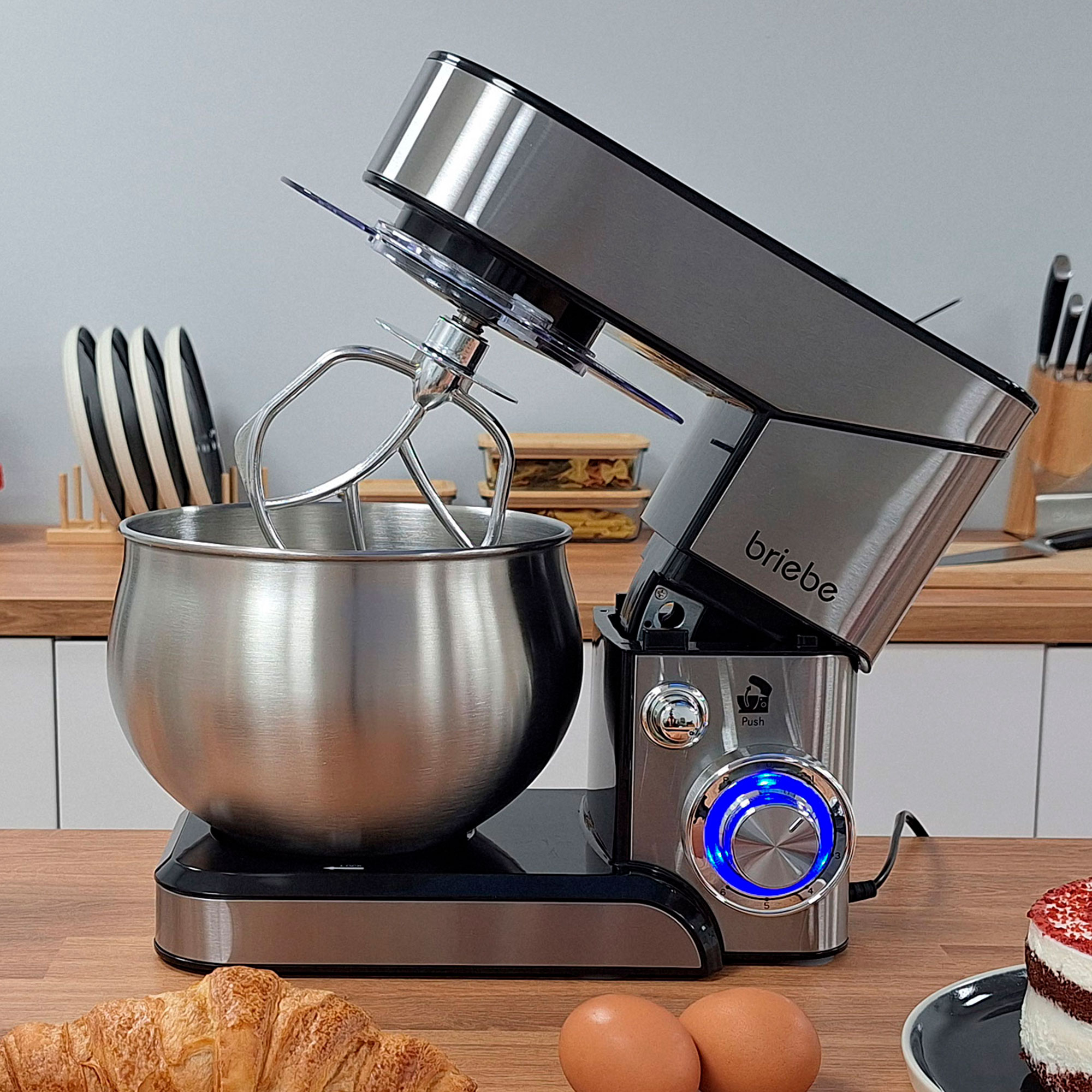 Ein silberner und schwarzer Standmixer mit geneigter Schüssel, der die internen Mischelemente zeigt.