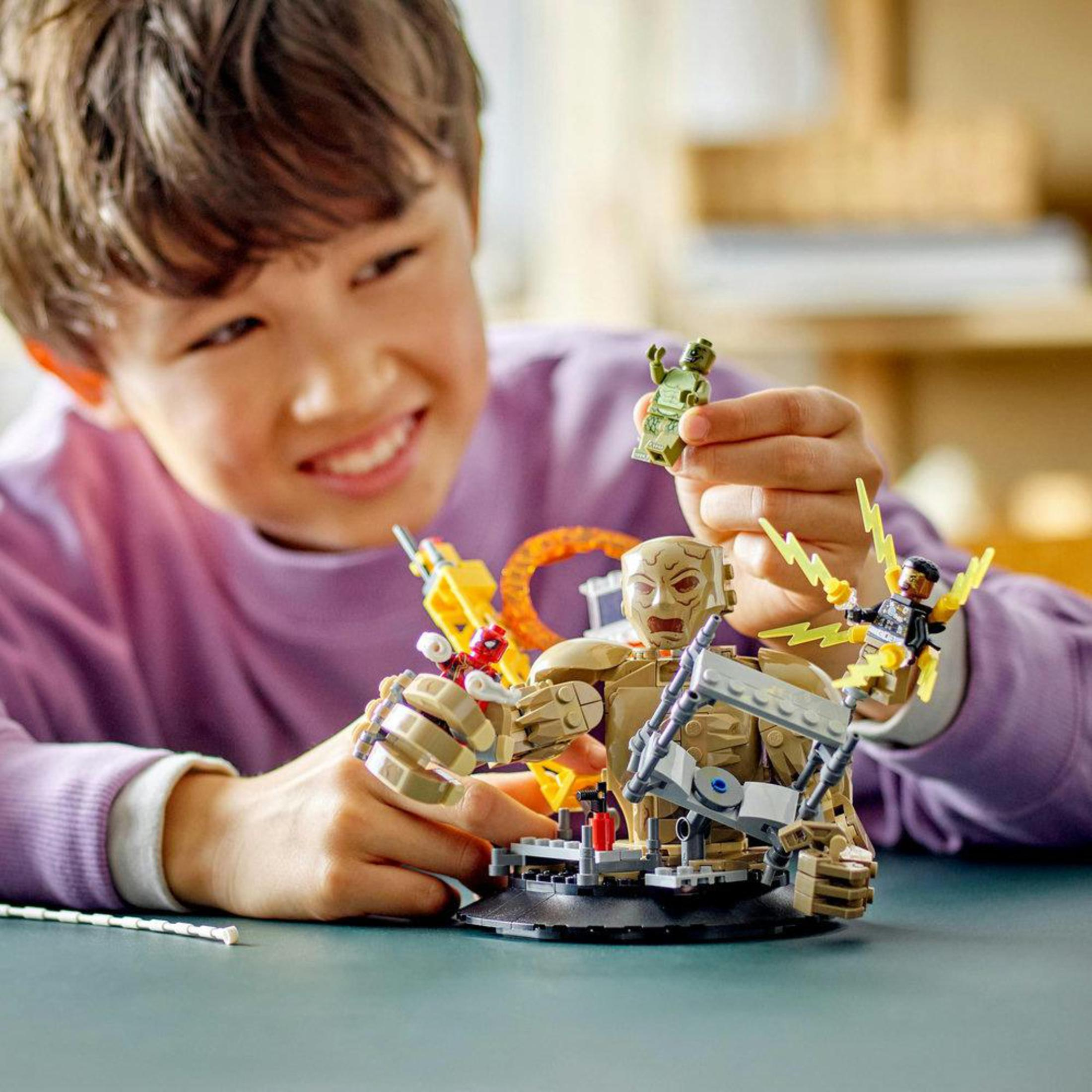 Ein Junge spielt mit einem Lego-Set mit einem Monster und Figuren. Ein Lego-Set mit den Händen eines Jungen.