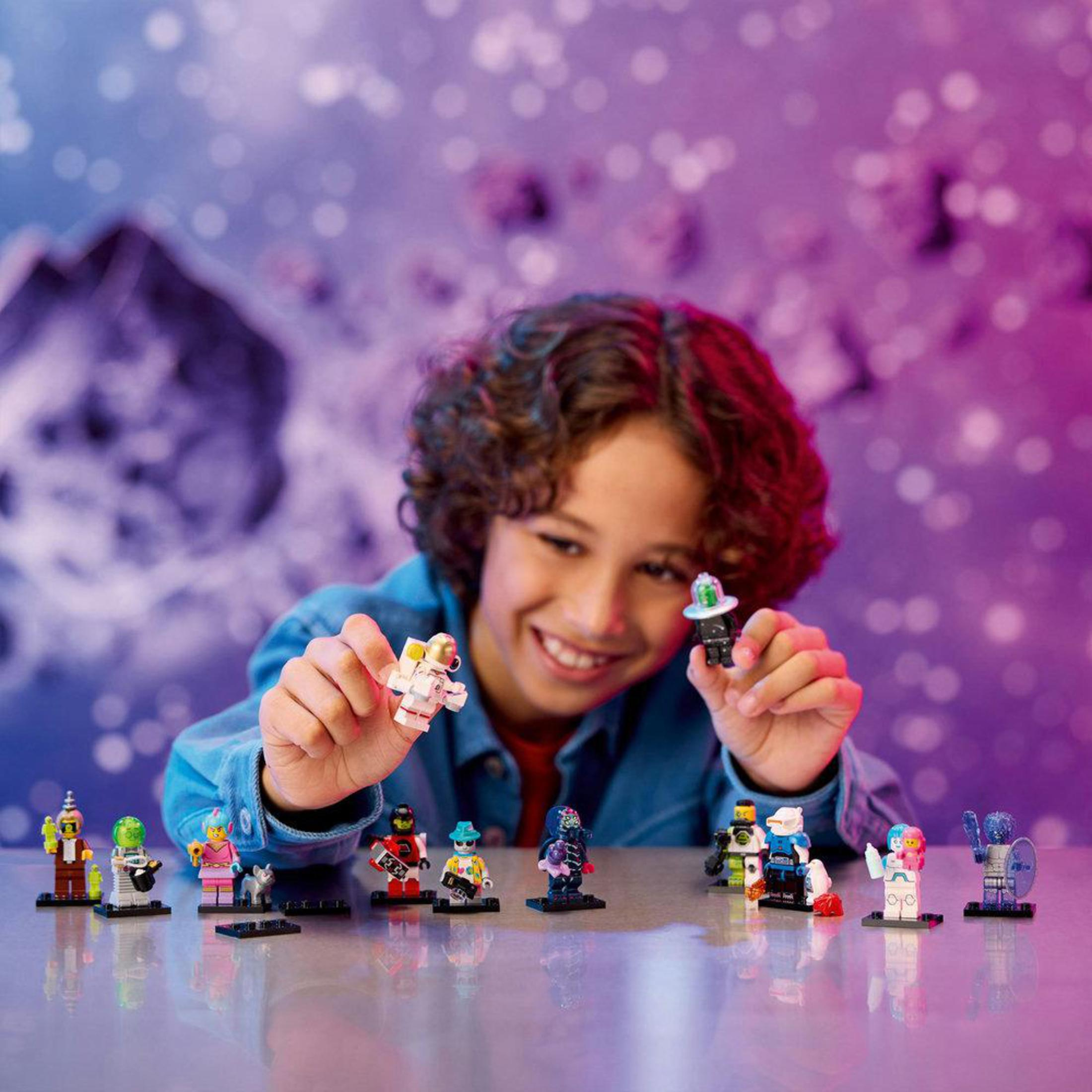 Un ragazzo tiene in mano personaggi Lego, una collezione di mini-figure.