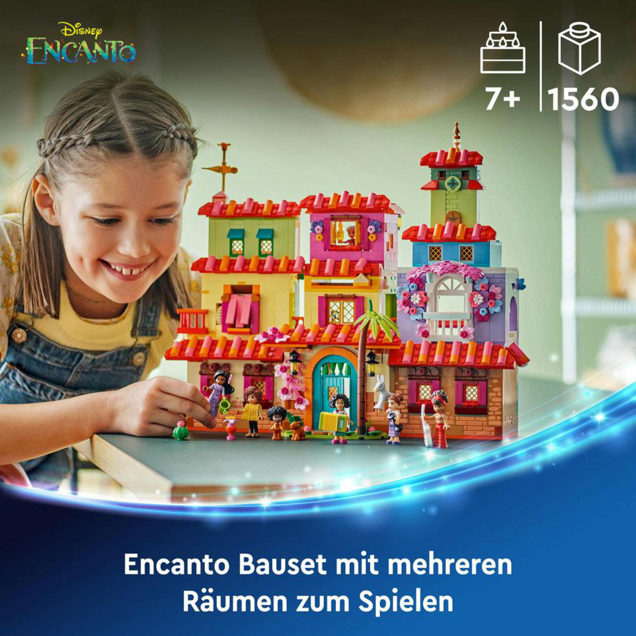 Ein junges Mädchen lächelt, während es mit einem Encanto Lego-Set spielt.