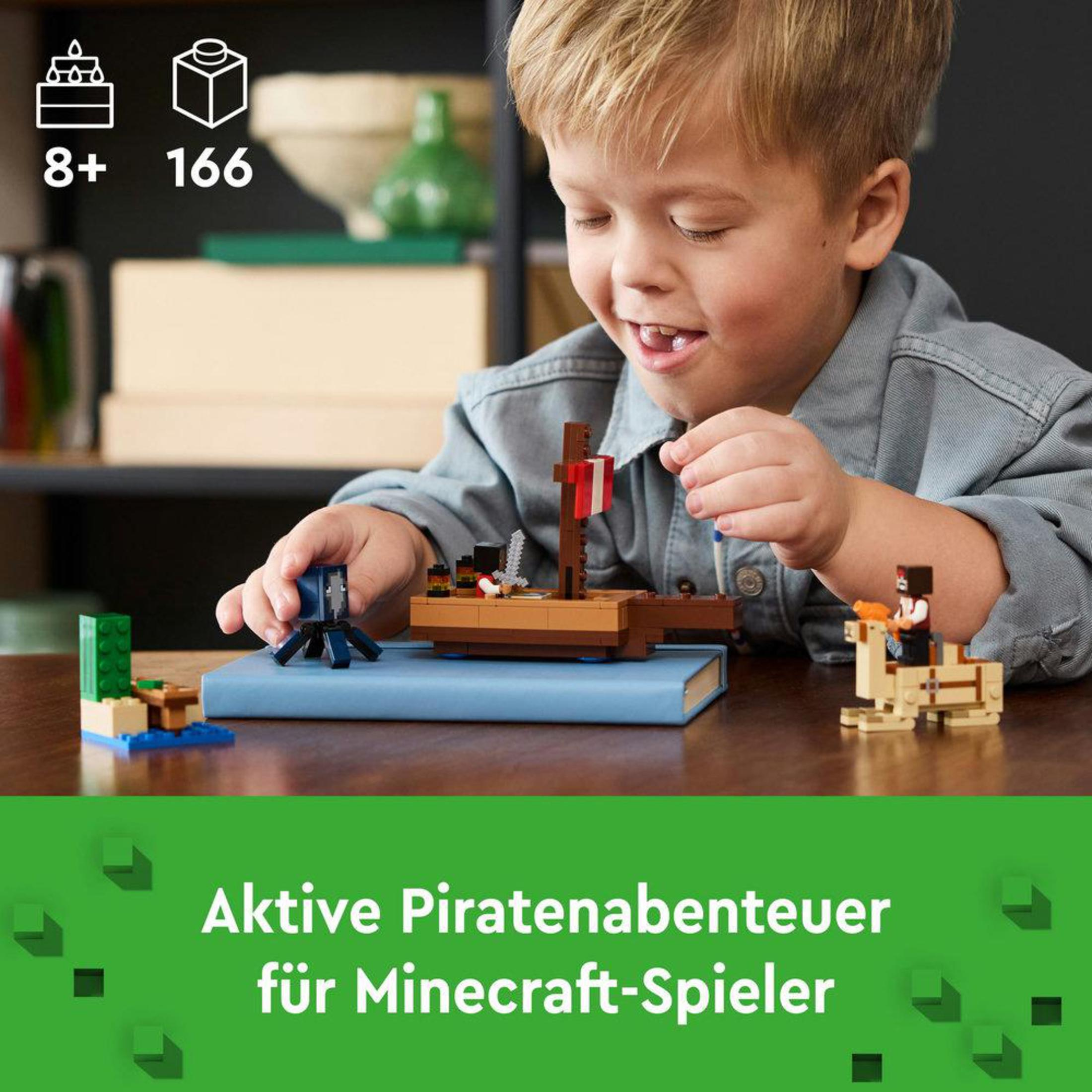 Een jongen die speelt met een Lego Minecraft piratenschipmodel op een blauw boek.