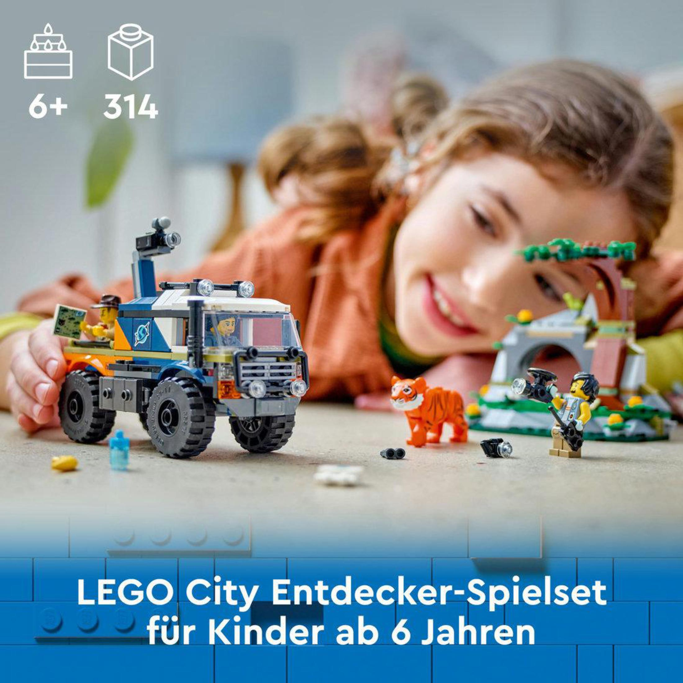 Zestaw Lego City z ciężarówką, tygrysem i dwiema figurkami Lego, z dzieckiem w tle.