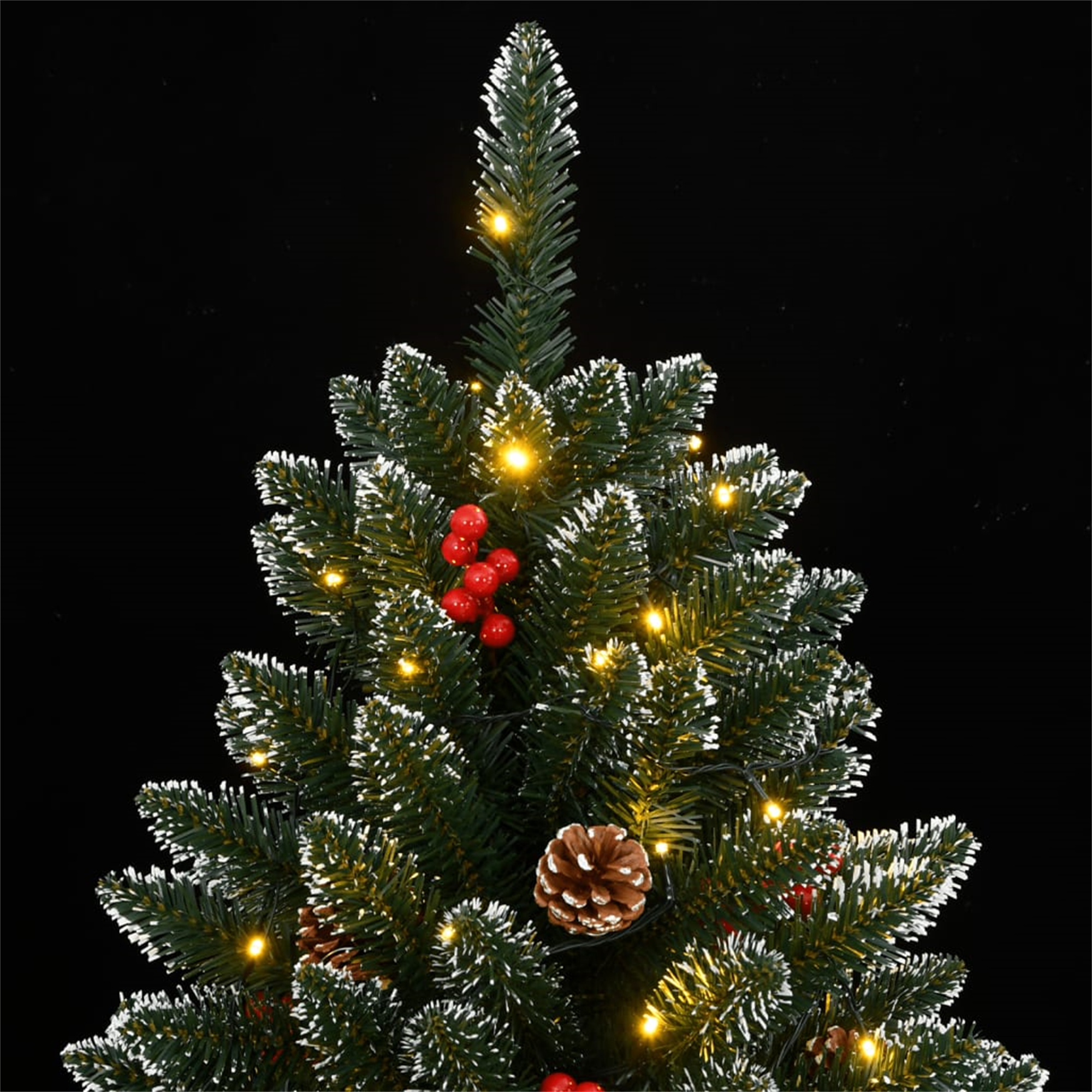 Nahaufnahme eines Weihnachtsbaums. Tannennadeln, rote Beeren, Tannenzapfen und kleine gelbe Lichter.
