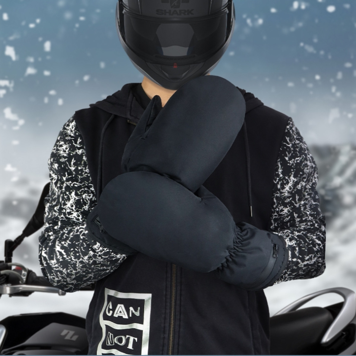 Persona con casco che indossa guanti neri in un ambiente nevoso.