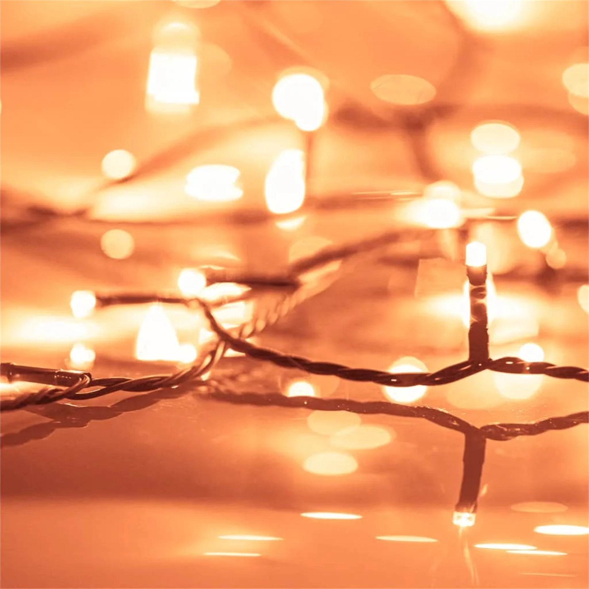 Nahaufnahme von orangefarbenen Lichterketten mit unscharfen Lichtern im Hintergrund.