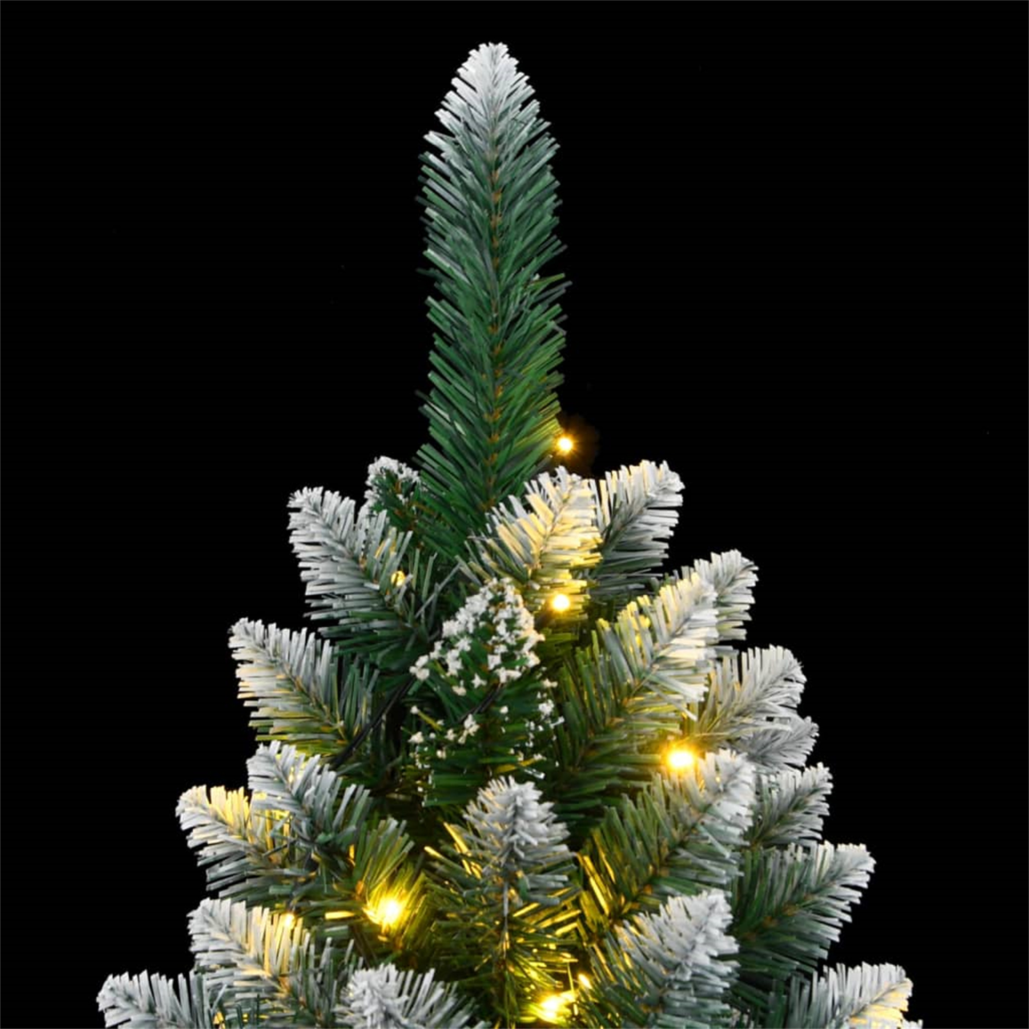 Oberseite eines Weihnachtsbaums mit weiß gefrosteten Ästen und gelben Lichtern, vor schwarzem Hintergrund.