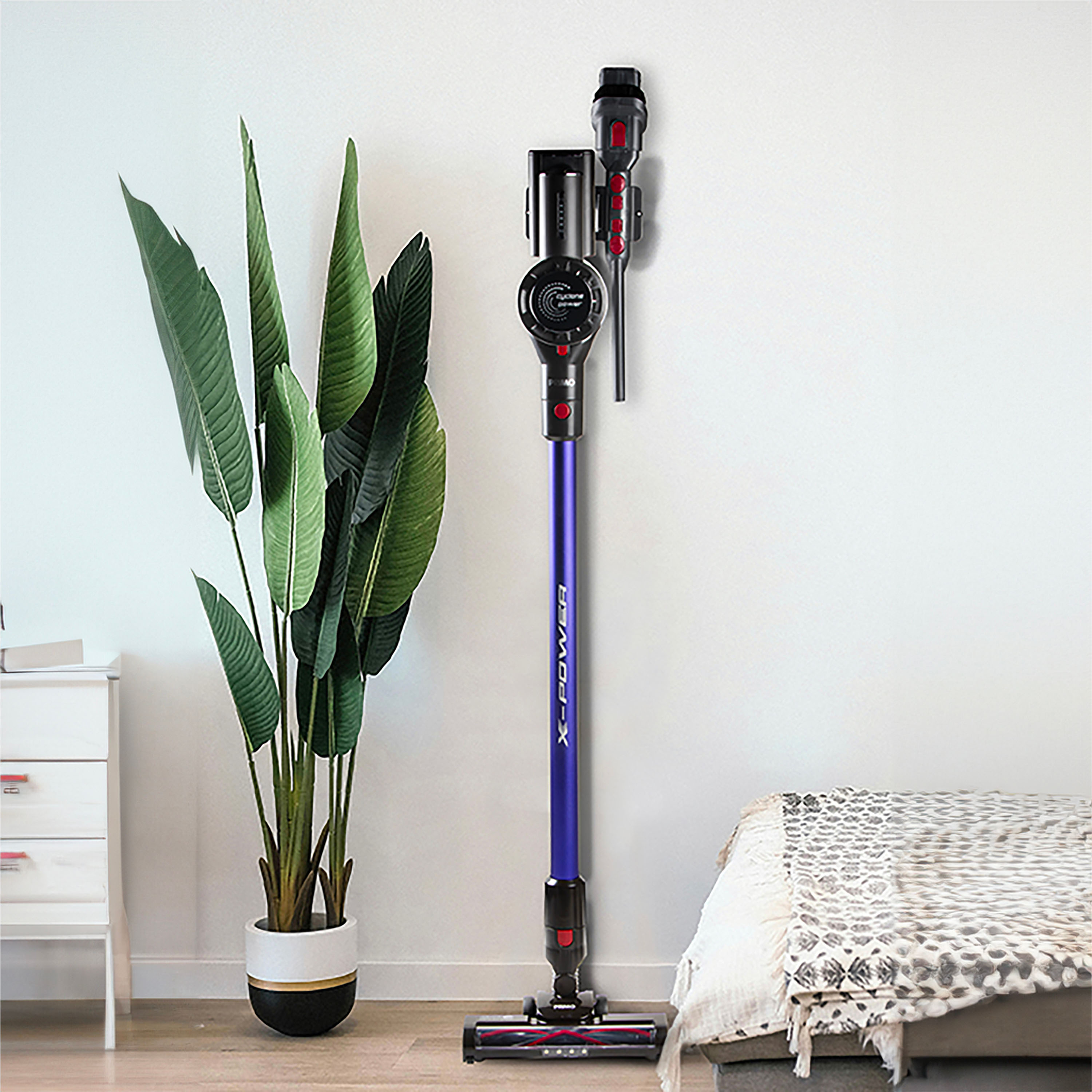 Un aspirateur bleu et violet à côté d'une plante.