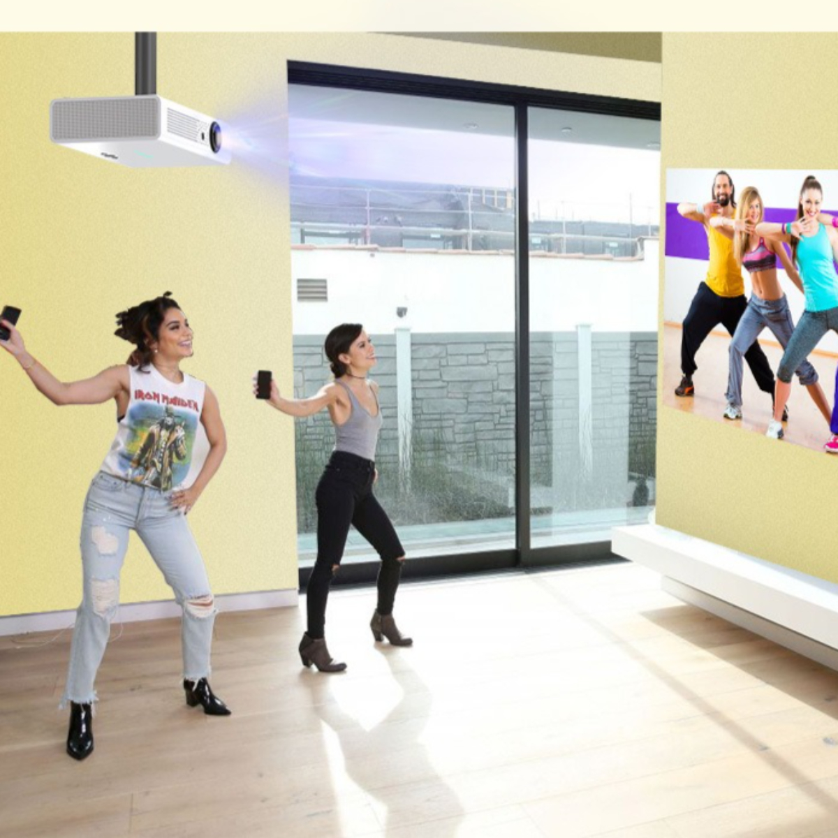 Zwei Frauen tanzen in einem Raum, während ein Projektor ein Bild an die Wand wirft.