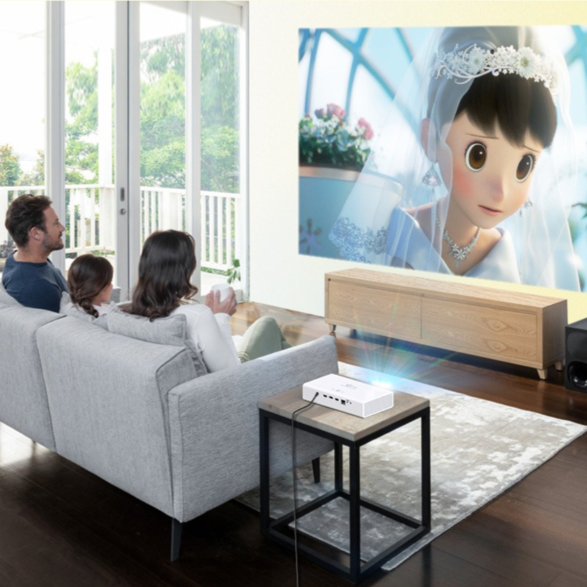 Eine Familie schaut einen Film, der auf eine Leinwand projiziert wird. Ein Projektor steht auf einem Tisch.