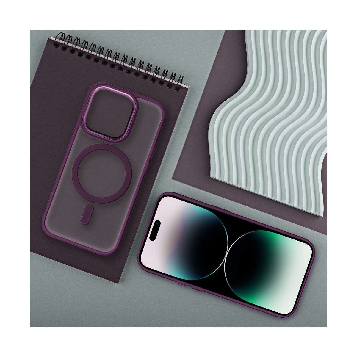 Custodia e telefono viola su un taccuino, accanto a un design ondulato verde pallido.
